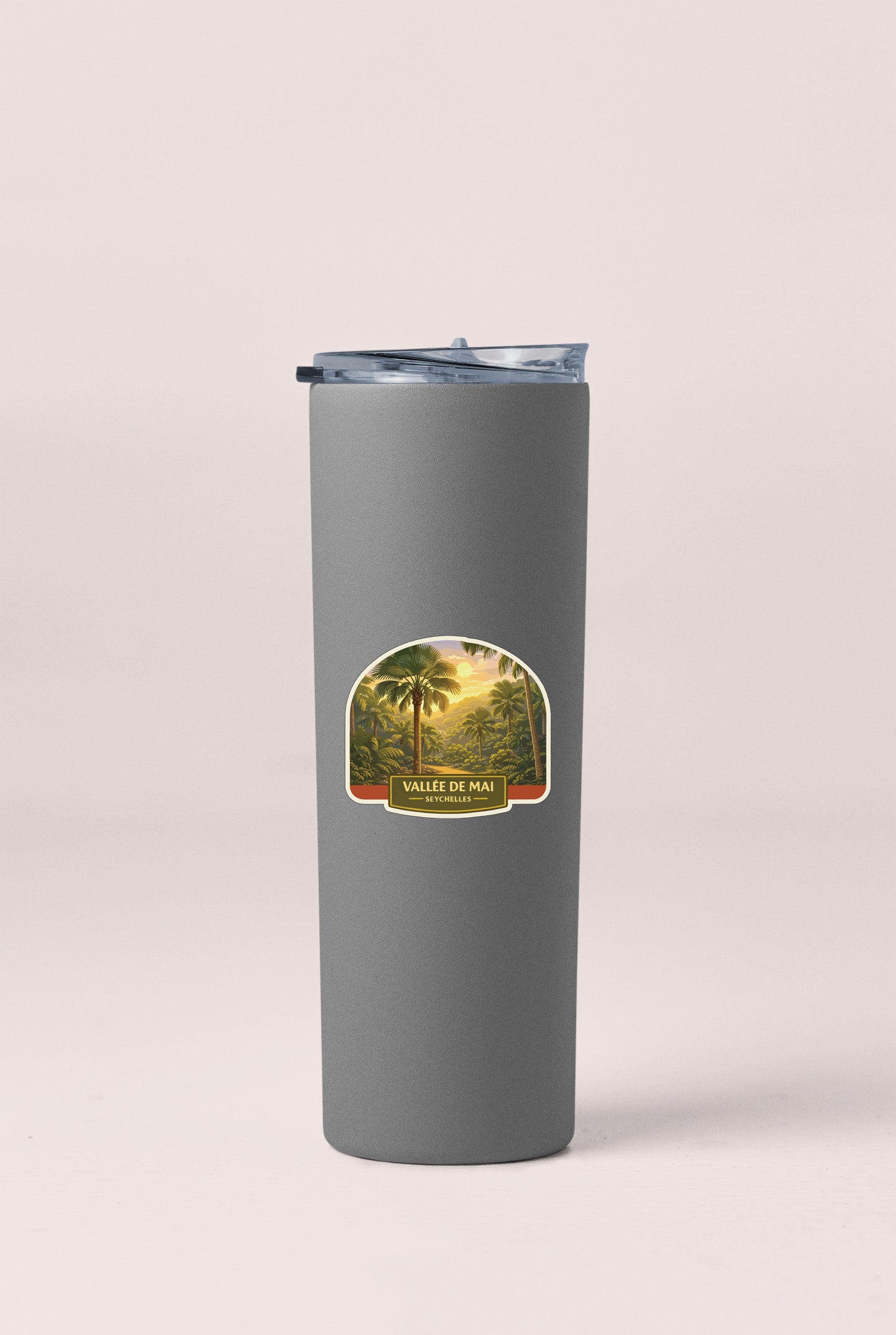 A gray insulated tumbler with a label depicting a tropical landscape.