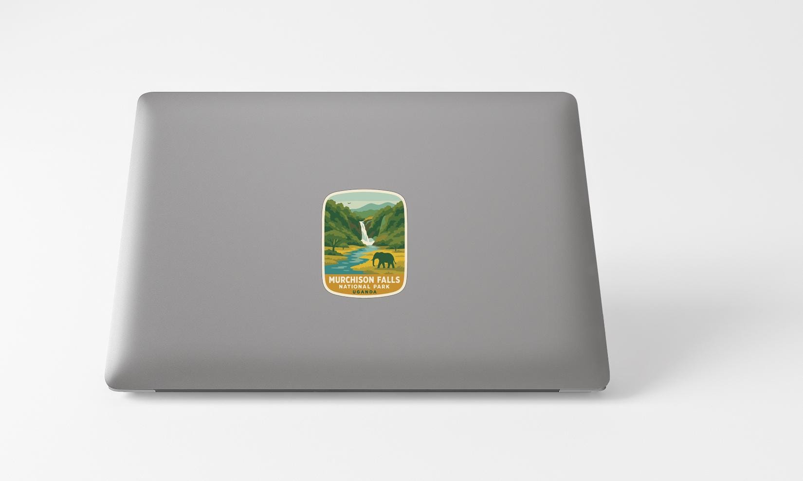 A sticker with a mountain landscape and a waterfall on a laptop.