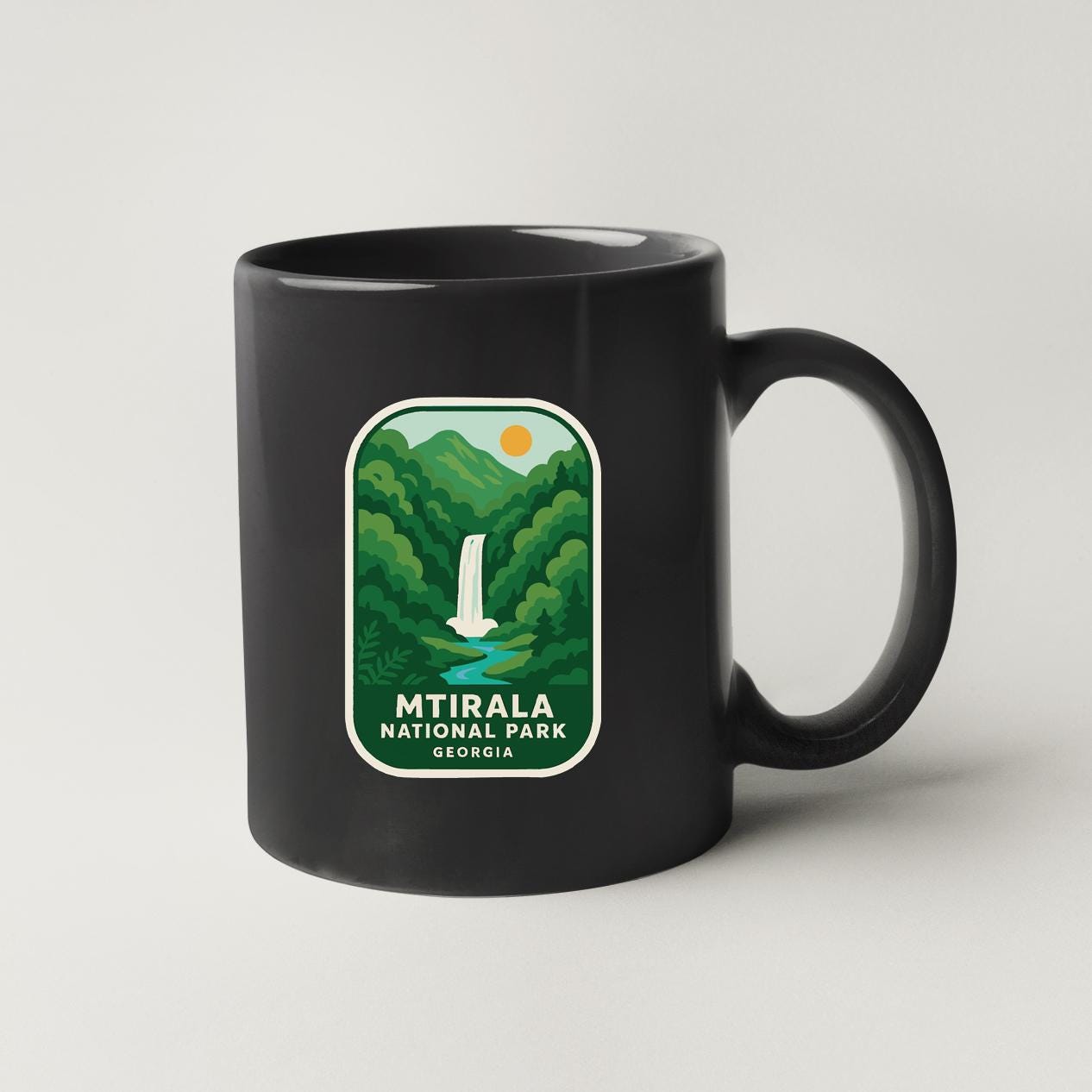 A black coffee mug with a green and white label that says "Mtirala National Park Georgia".