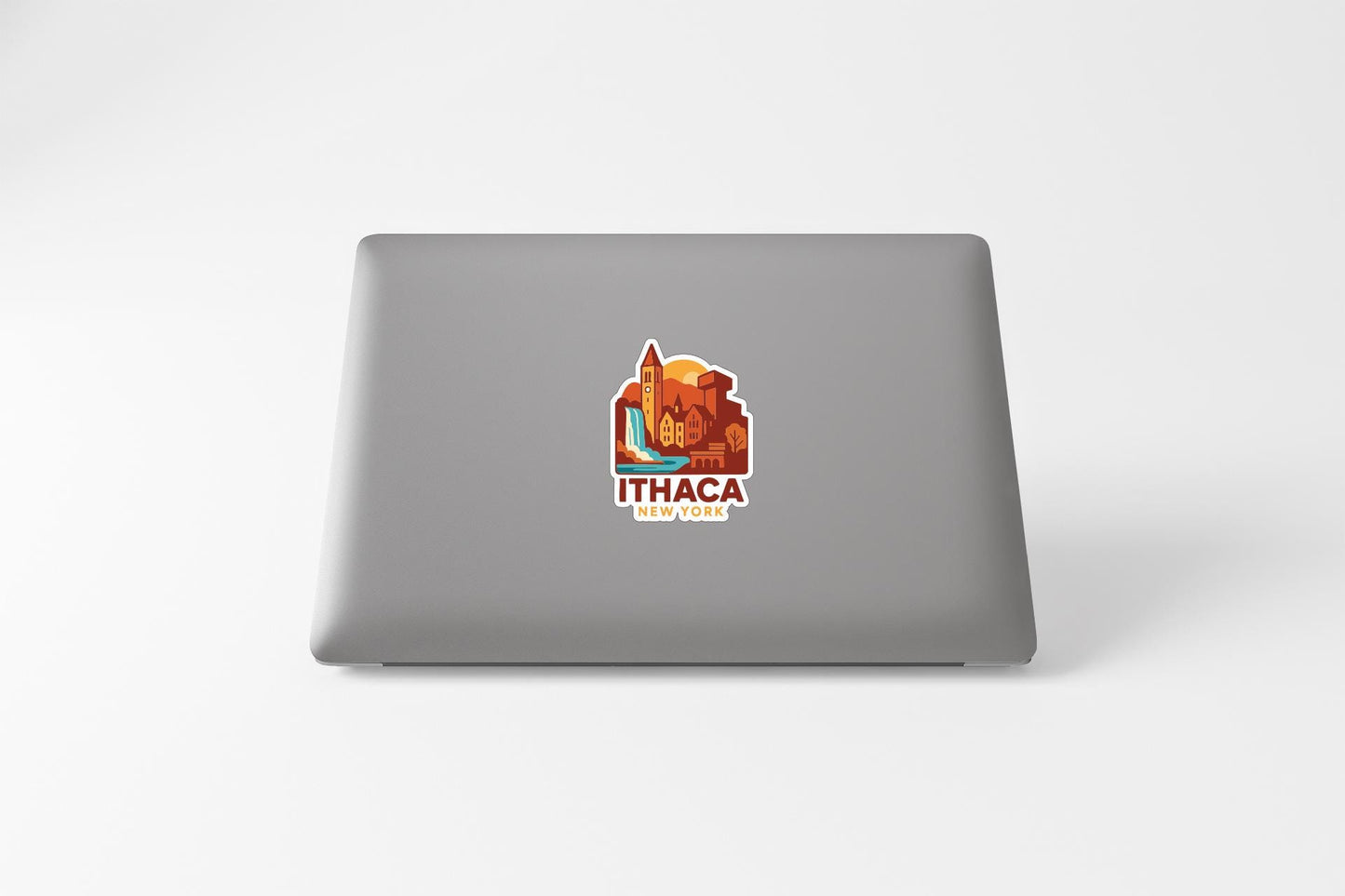 a sticker with an illustration of a cityscape on the back of a laptop.