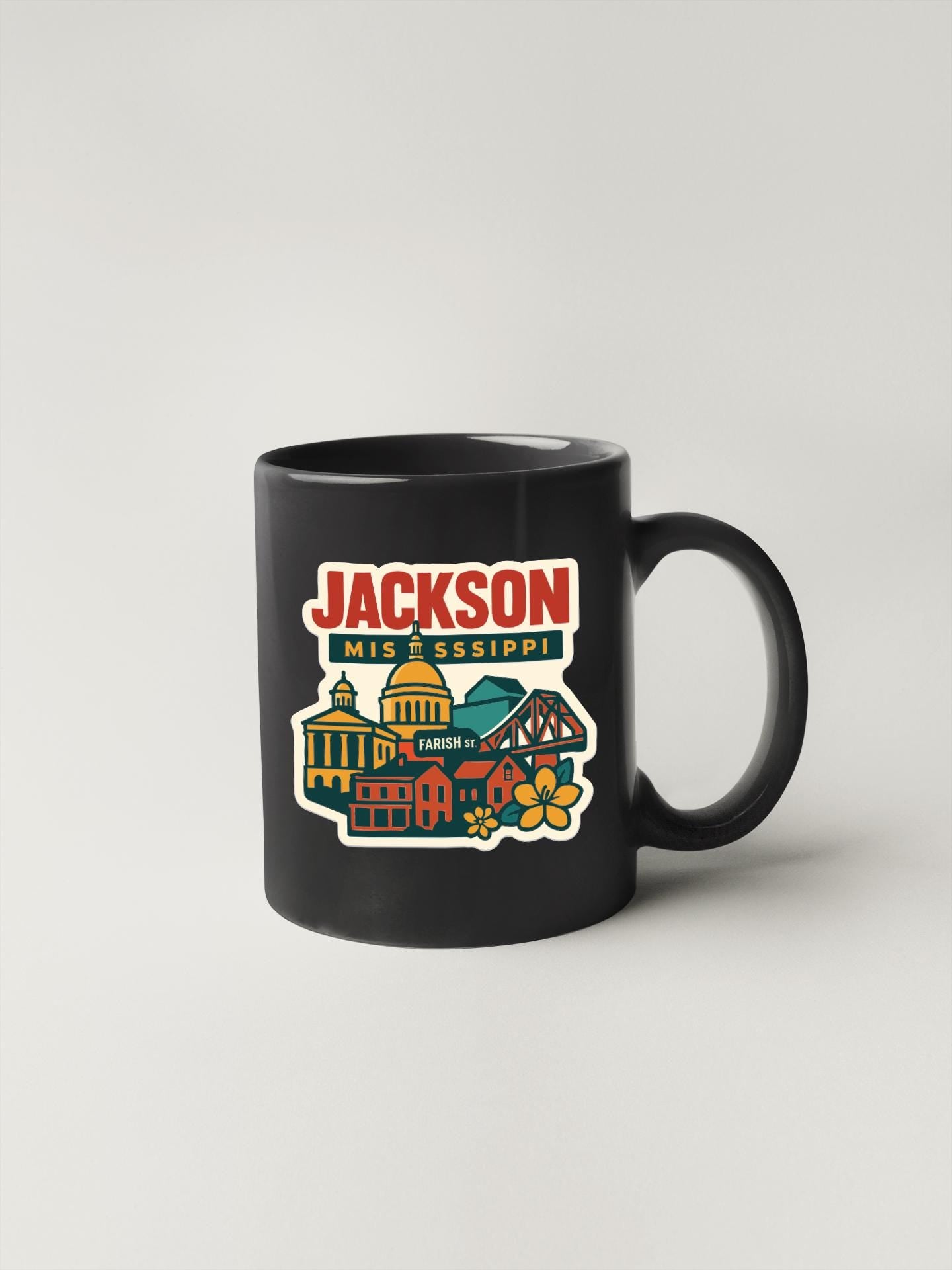 A black coffee mug with a colorful illustration of a cityscape and the text "JACKSON MIS & SISSIPI" printed on it.