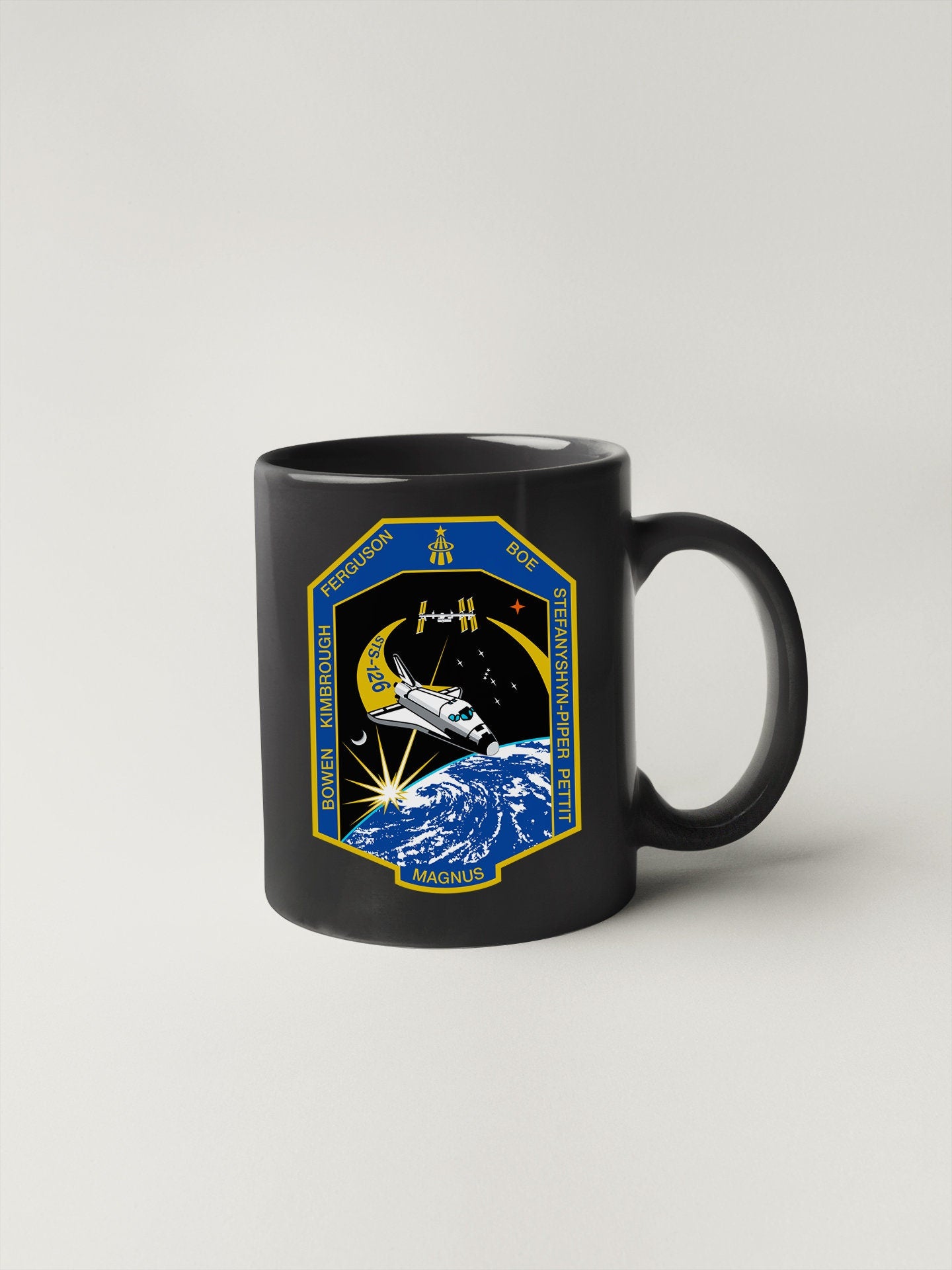 a black coffee mug with a space shuttle on it
