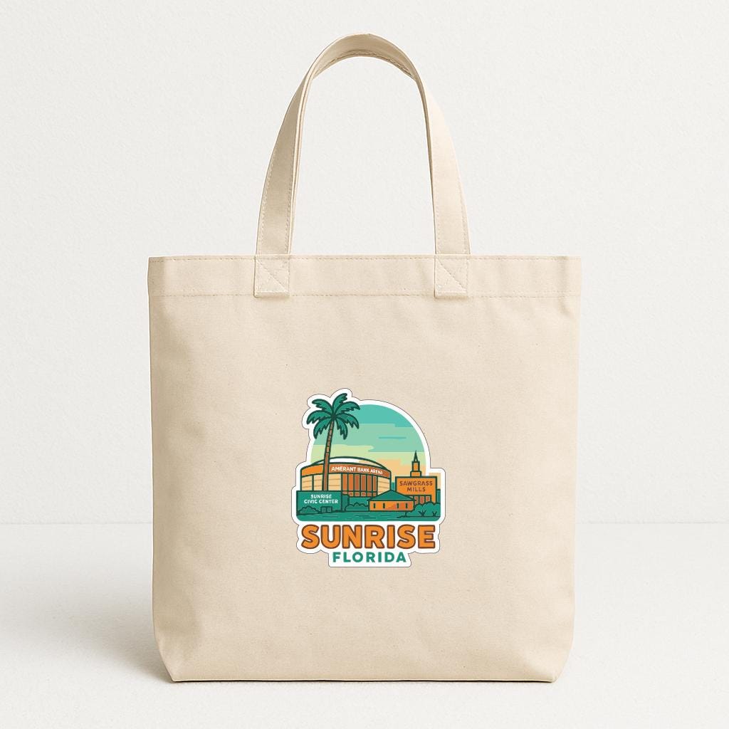 A beige tote bag with a graphic design depicting a palm tree and a building, along with the text "SUNRISE FLORIDA".
