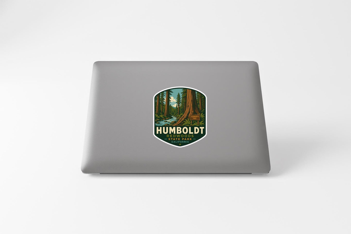 a sticker with a forest scene on a laptop.