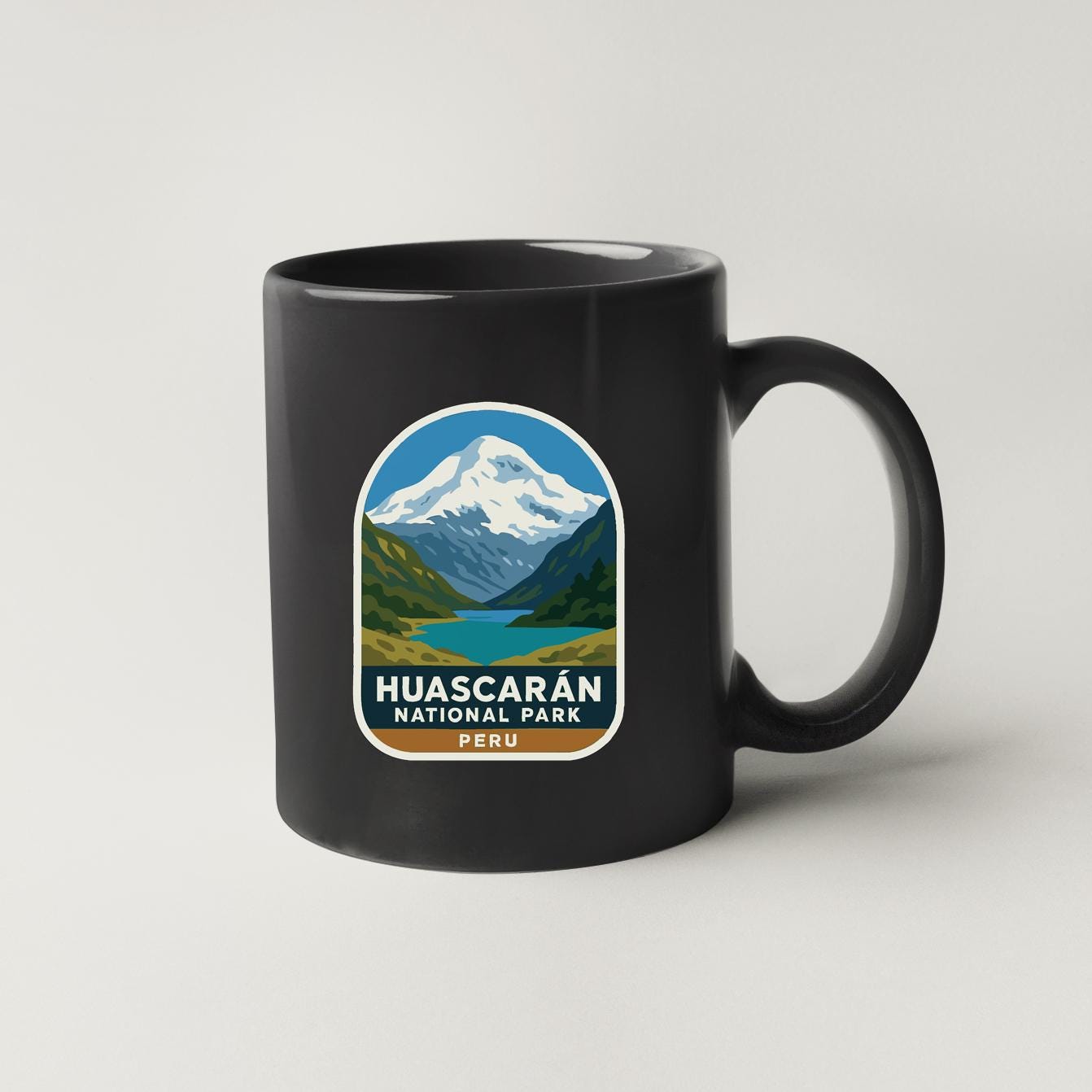 A black coffee mug with a graphic design depicting Huascaran National Park in Peru.