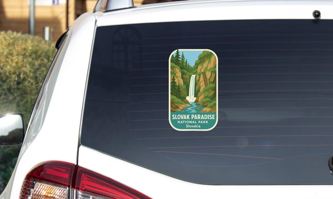 A sticker on the rear window of a white car, depicting a scenic waterfall in the Slovak Paradise National Park, Slovakia.