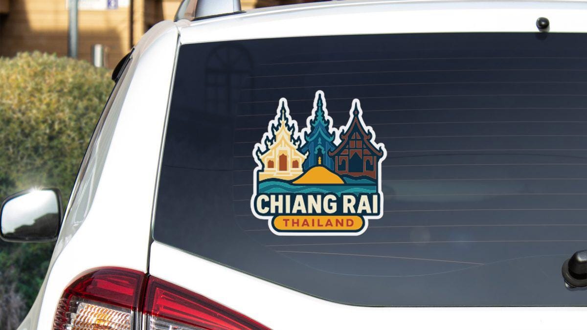 A sticker on the rear window of a car that says "CHIANG RAI THAILAND".
