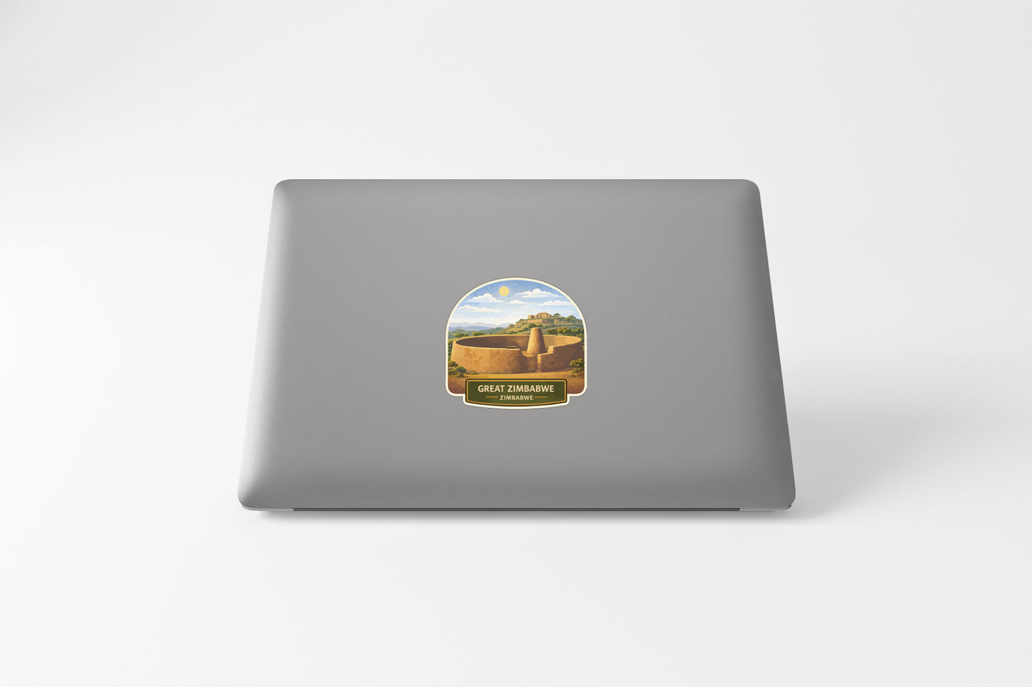 a sticker on the back of a laptop, depicting a desert landscape with a cactus and a mountain range in the background.