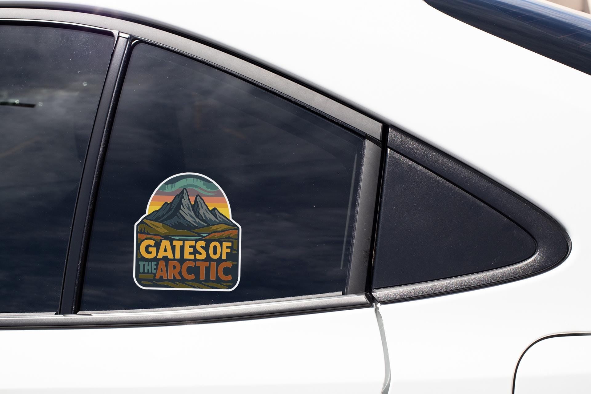 A car window with a sticker on it that says "GATES OF THE ARCTIC".