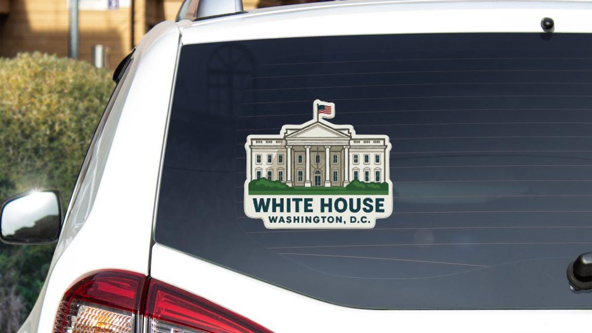 a sticker on the rear window of a white car that displays the White House in Washington, D.C.