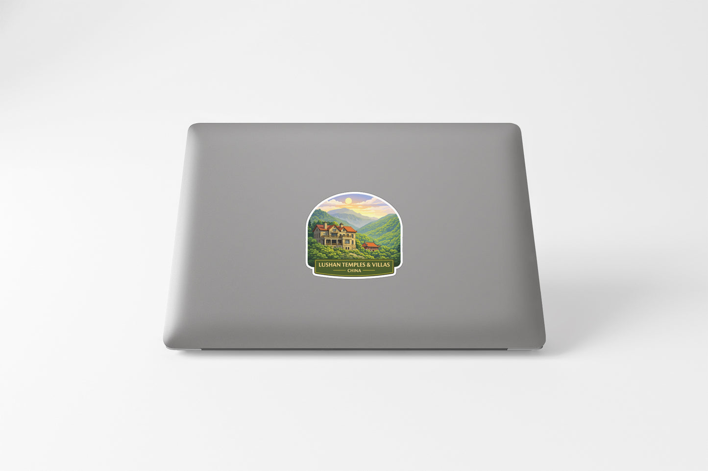 A sticker depicting a scenic landscape with a house and mountains in the background.
