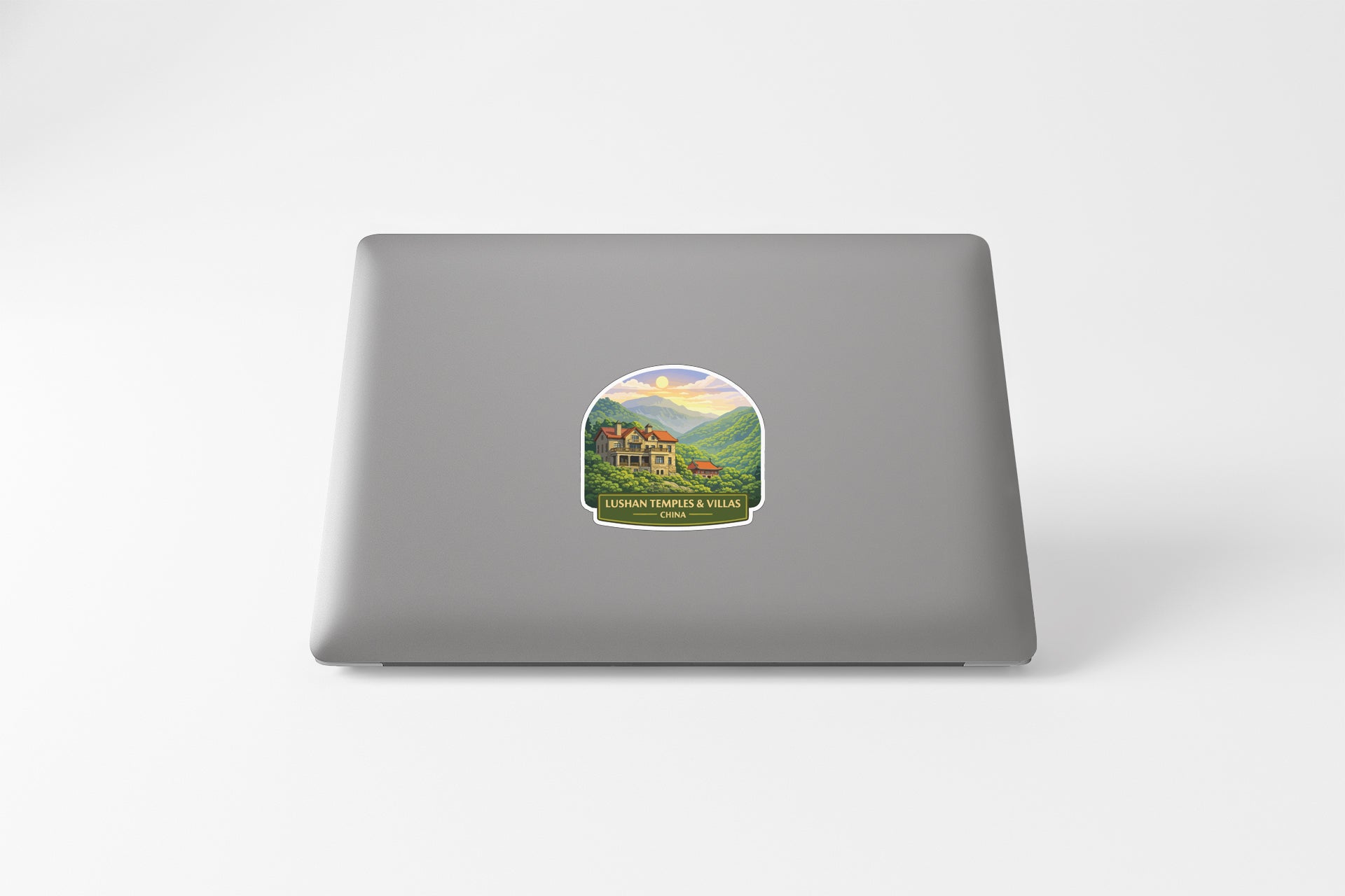 A sticker depicting a scenic landscape with a house and mountains in the background.