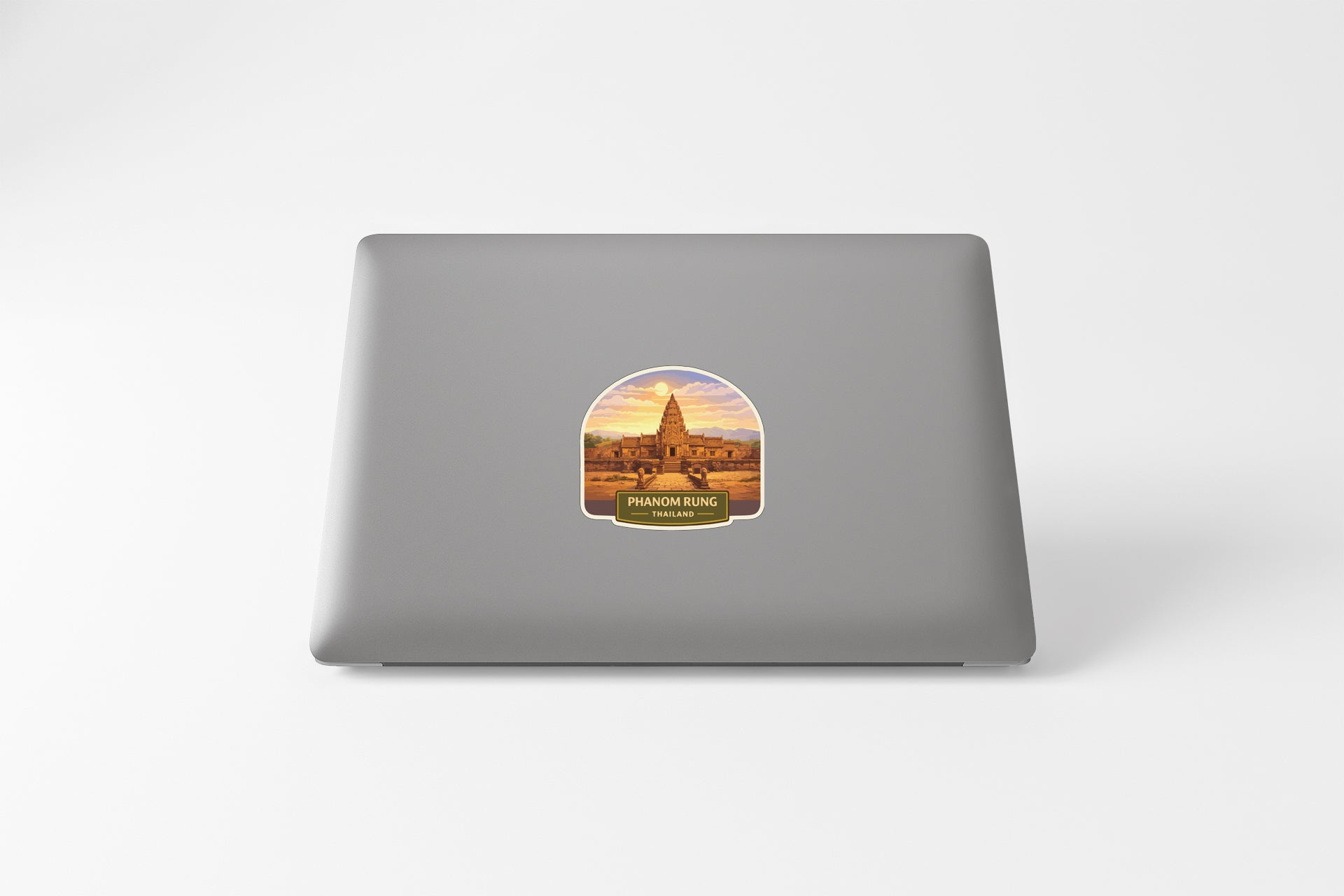a sticker with an illustration of a temple or building, placed on the back of a laptop computer.