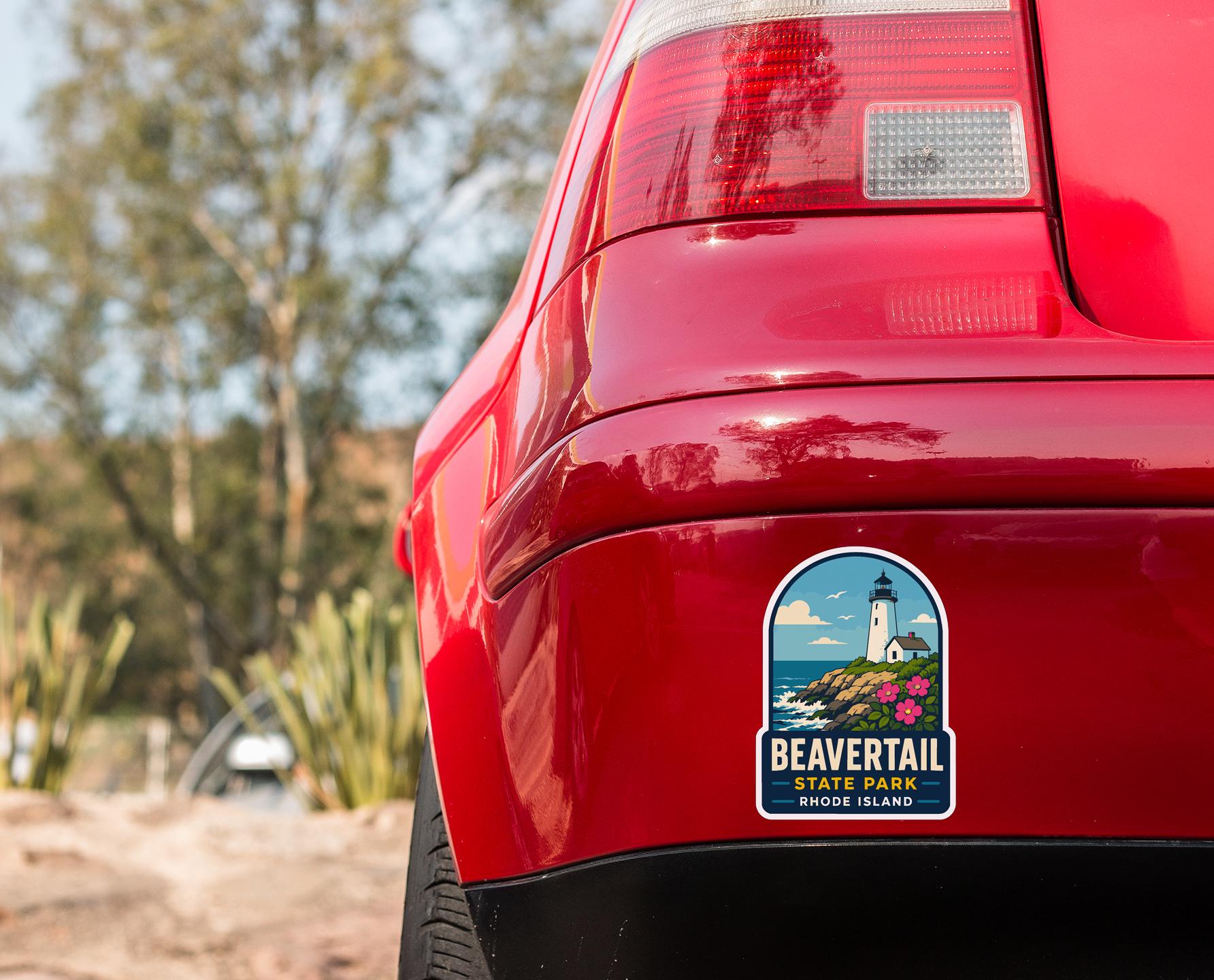 the rear end of a red car with a sticker on the back window that says "BEAVERTail State Park Rhode Island".
