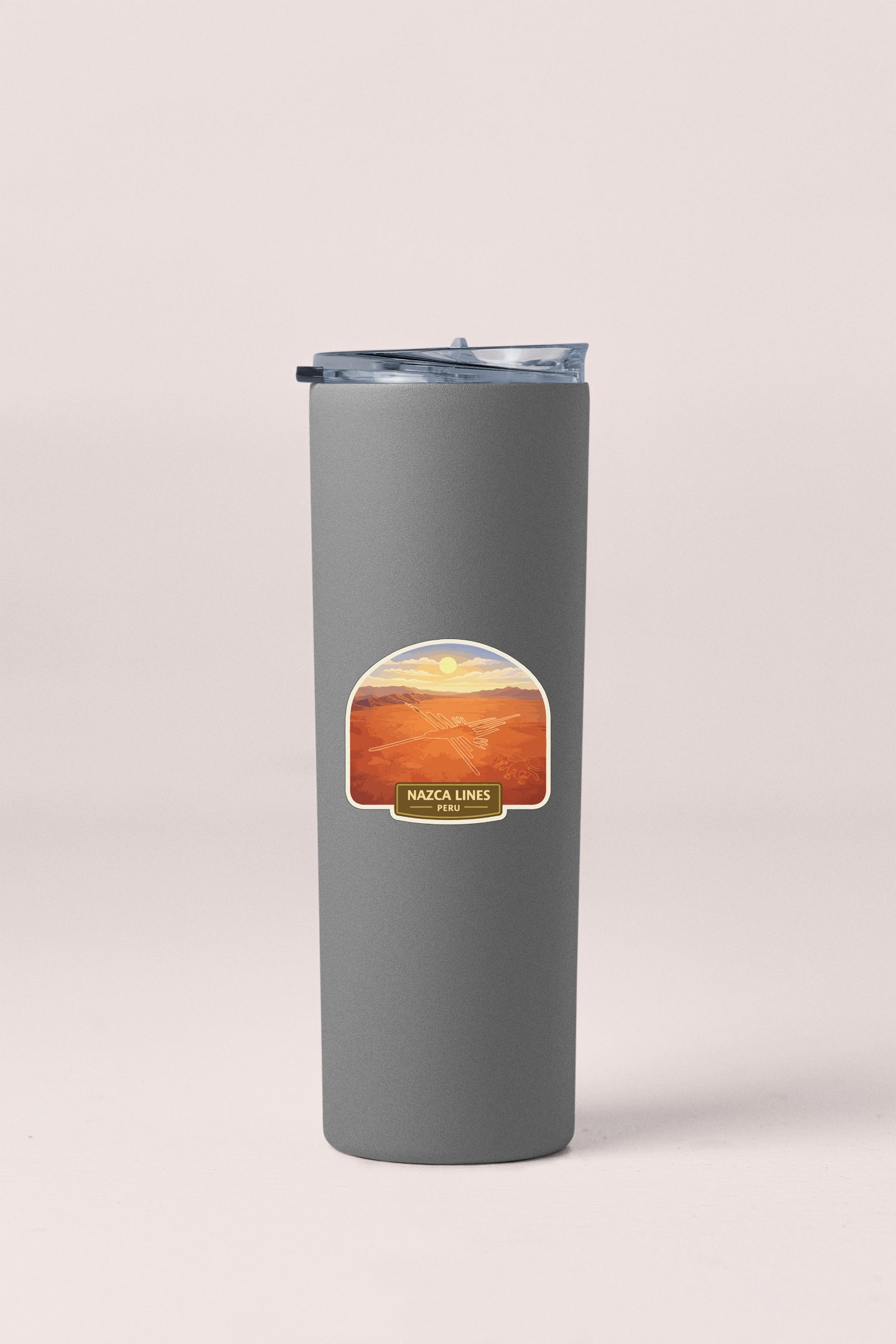 A gray cylindrical container with a lid and a label featuring an image of a desert landscape with a sunset.