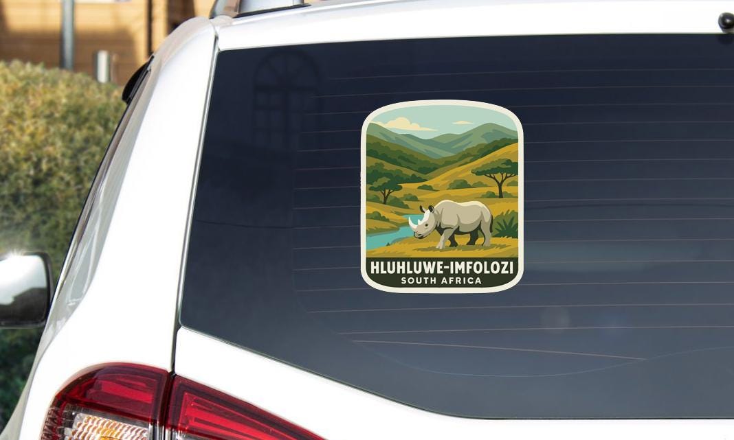 A sticker on the rear window of a car, depicting a rhinoceros in a natural landscape.