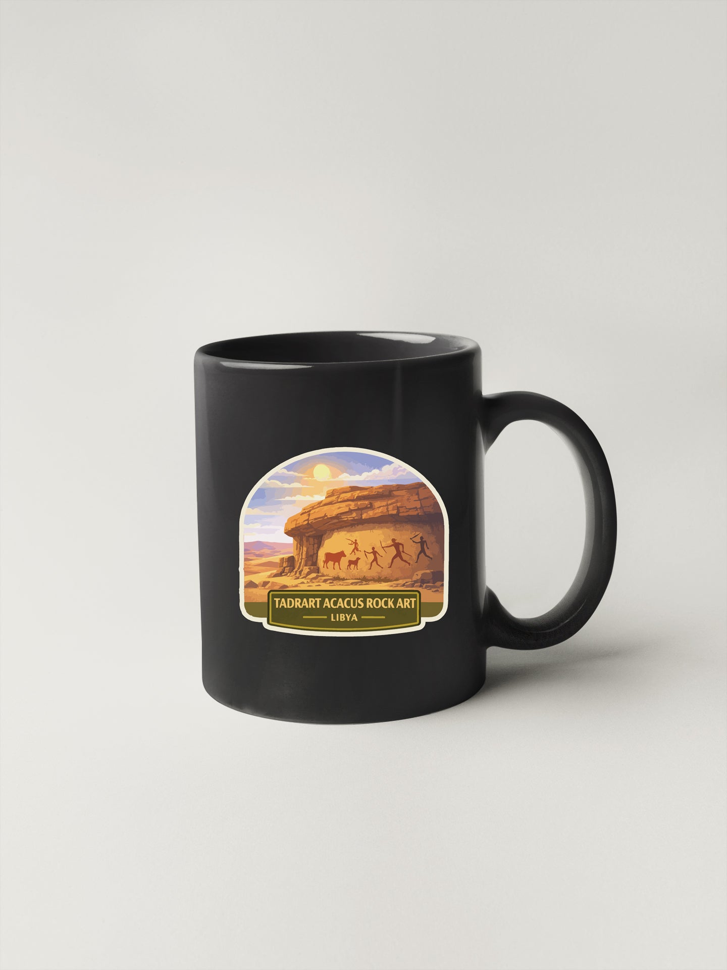 A black coffee mug with a label that says "TADRART ACACUS ROCK ART LIBIA".