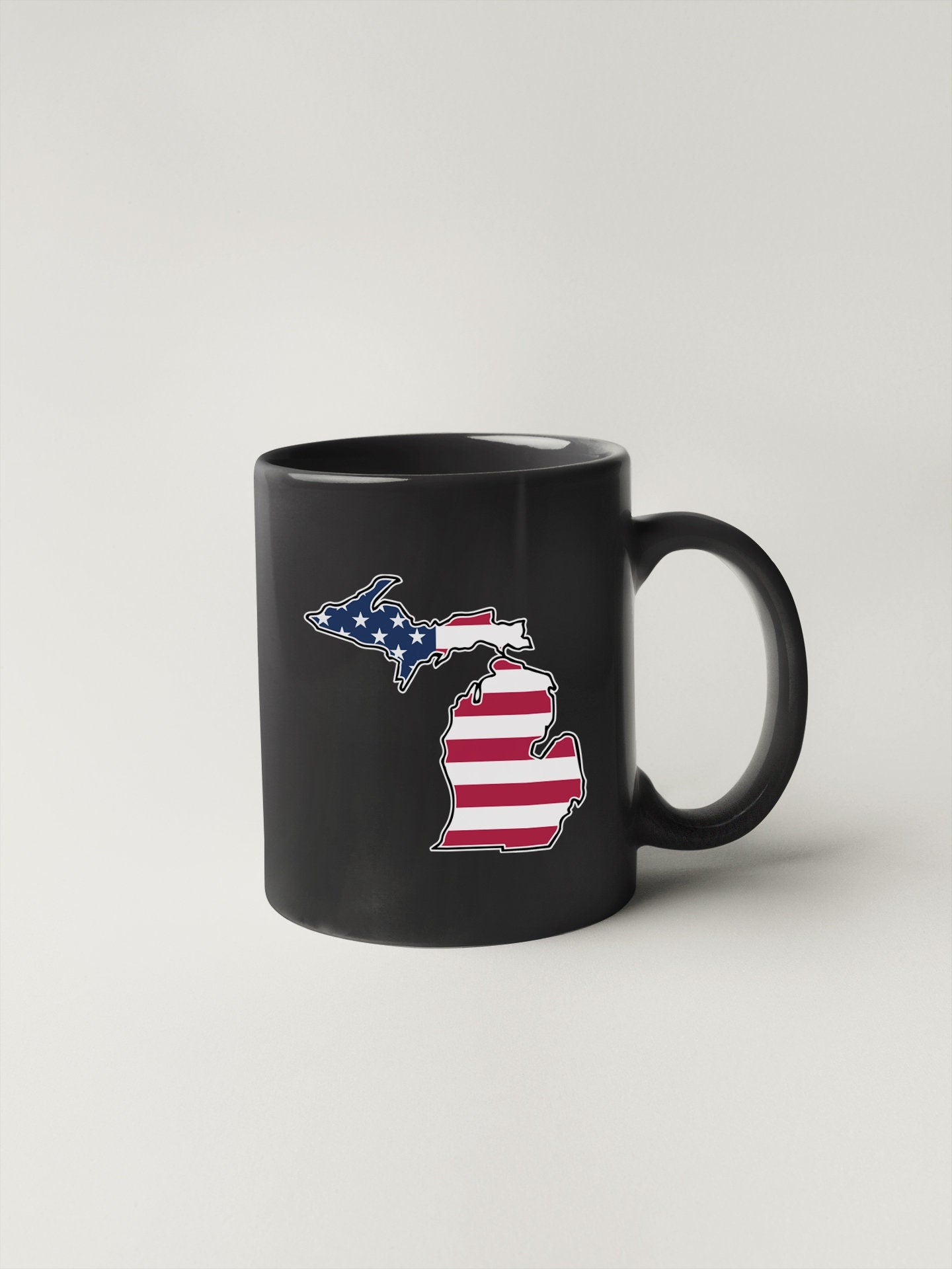 a black coffee mug with the state of michigan on it