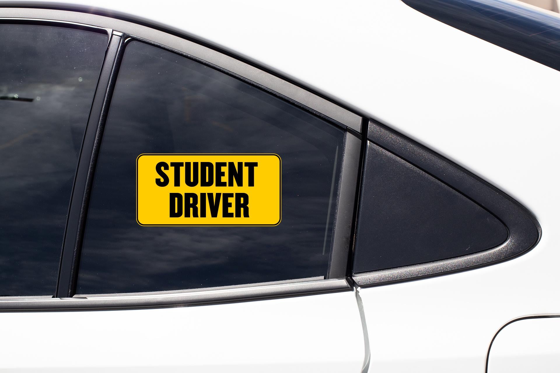a yellow student driver sign on the side of a car