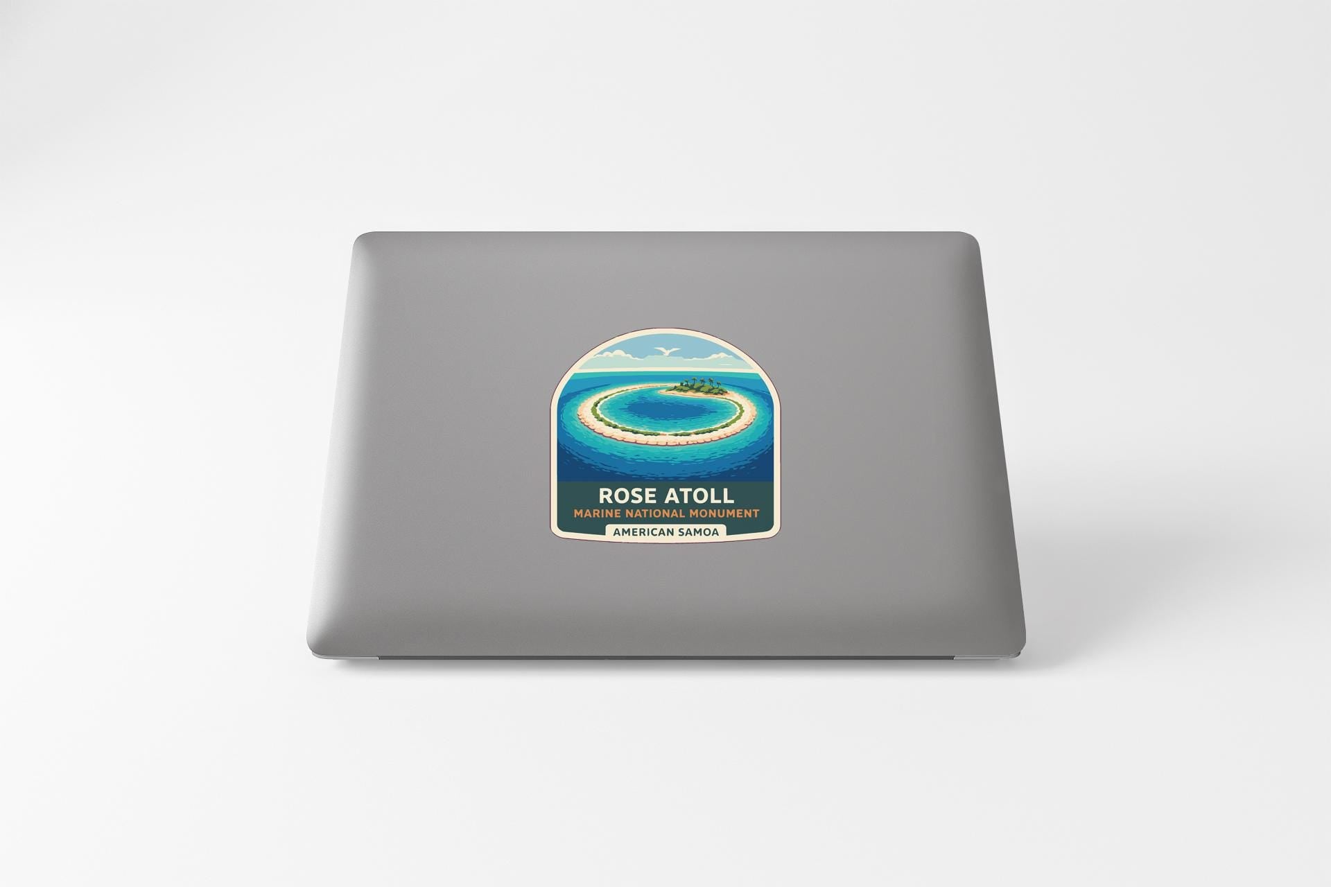 a sticker on a laptop with a tropical island and ocean scene.