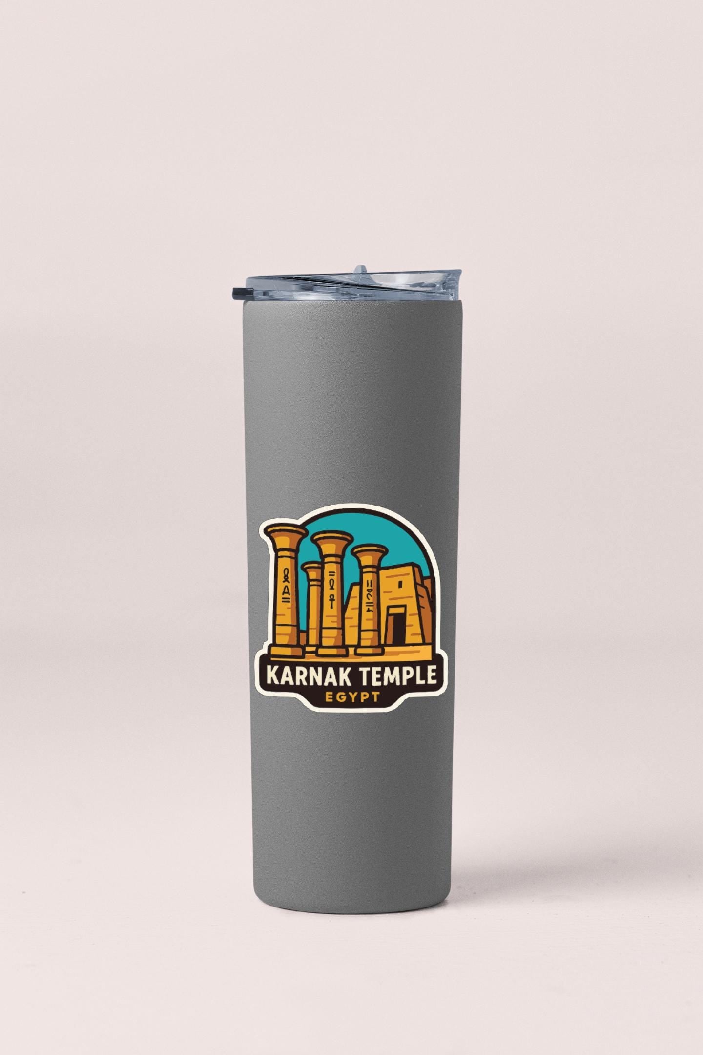 A gray tumbler with a sticker depicting the Karnak Temple in Egypt.