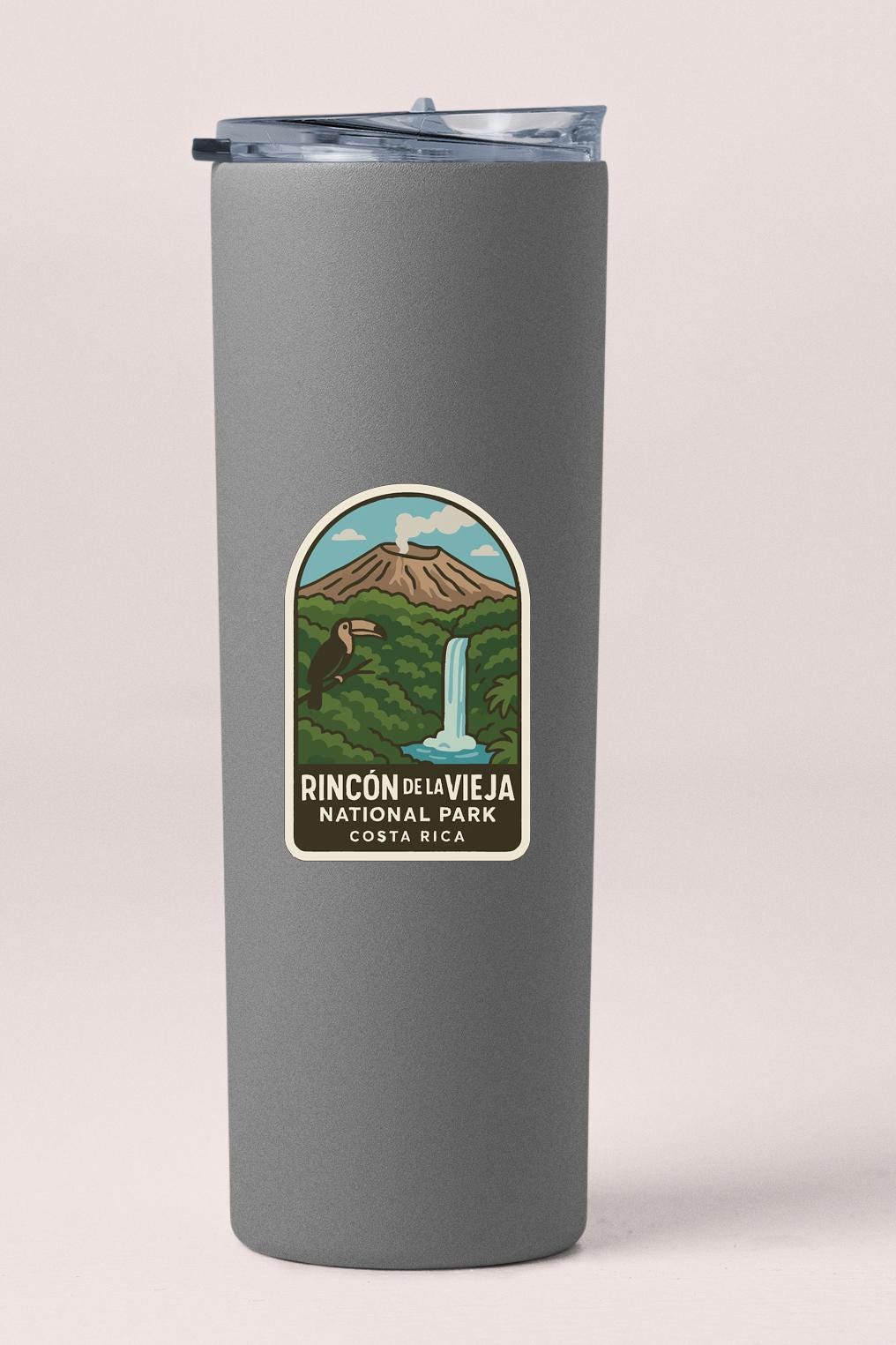 A gray insulated tumbler with a label that features an illustration of a waterfall and a mountain, along with the text "Rincón del Viejama National Park Costa Rica".