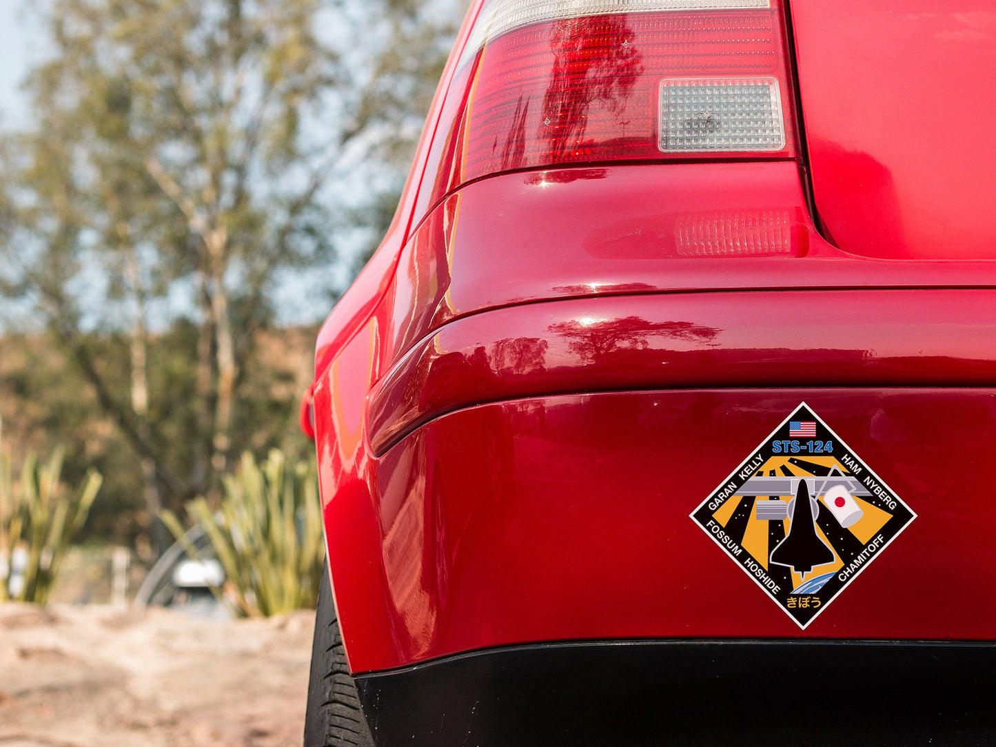 a close up of a red car with a sticker on it