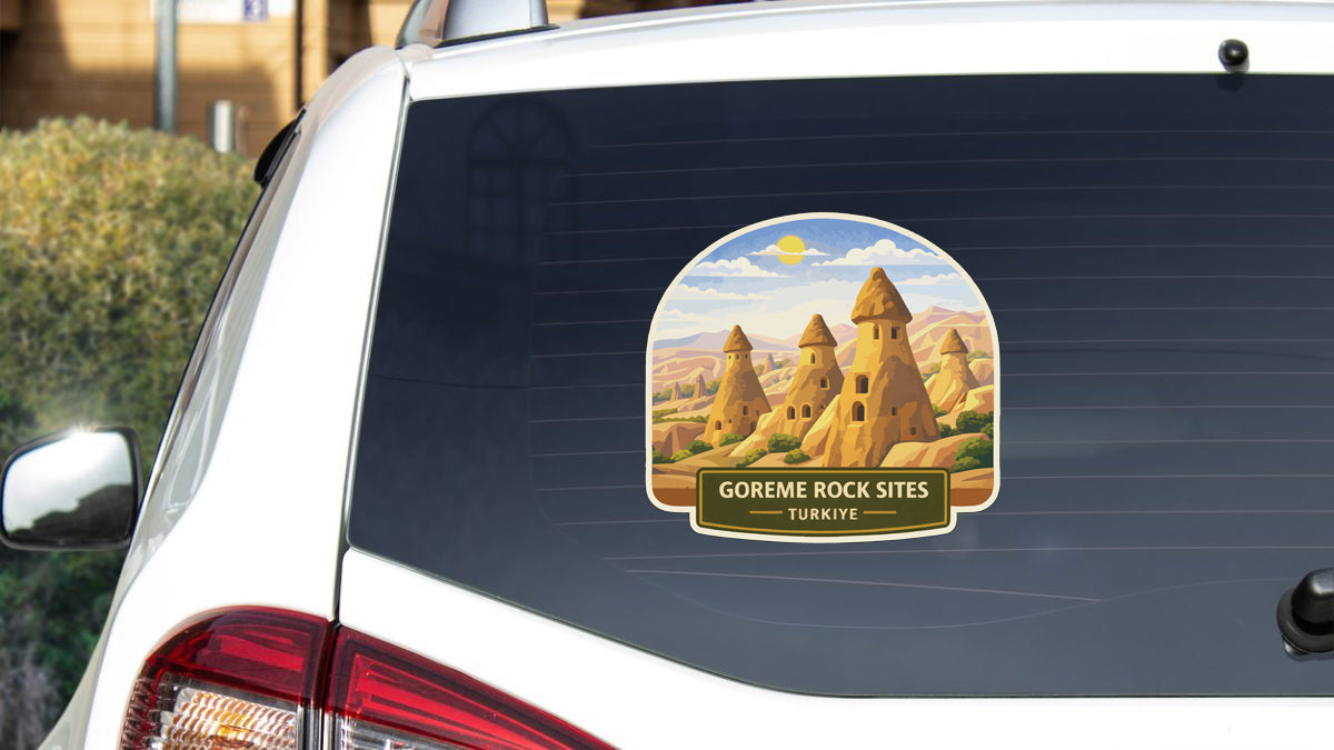 a sticker on the rear window of a car that depicts a desert landscape with several sandstone structures, likely representing the Gorem Rock Sites in Turkey.