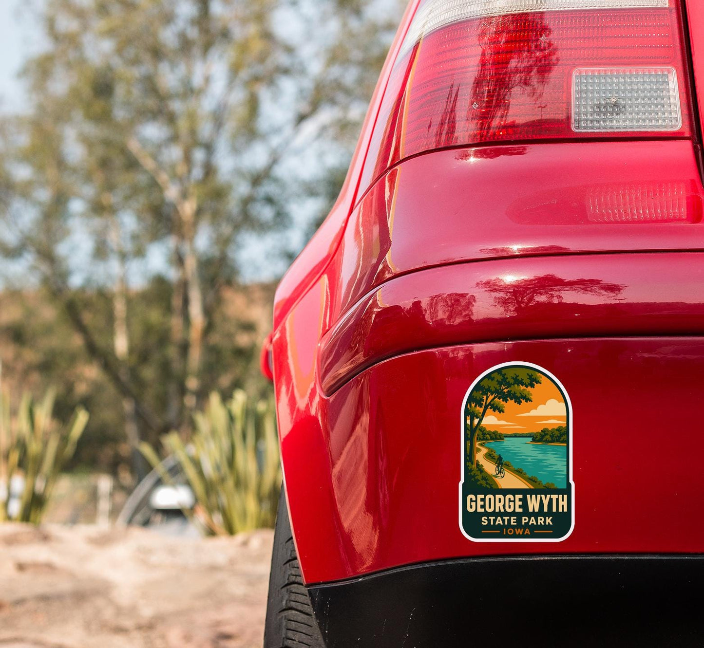 the rear end of a red car with a sticker on the back window that reads "GEORGE WYTH STATE PARK IDA".
