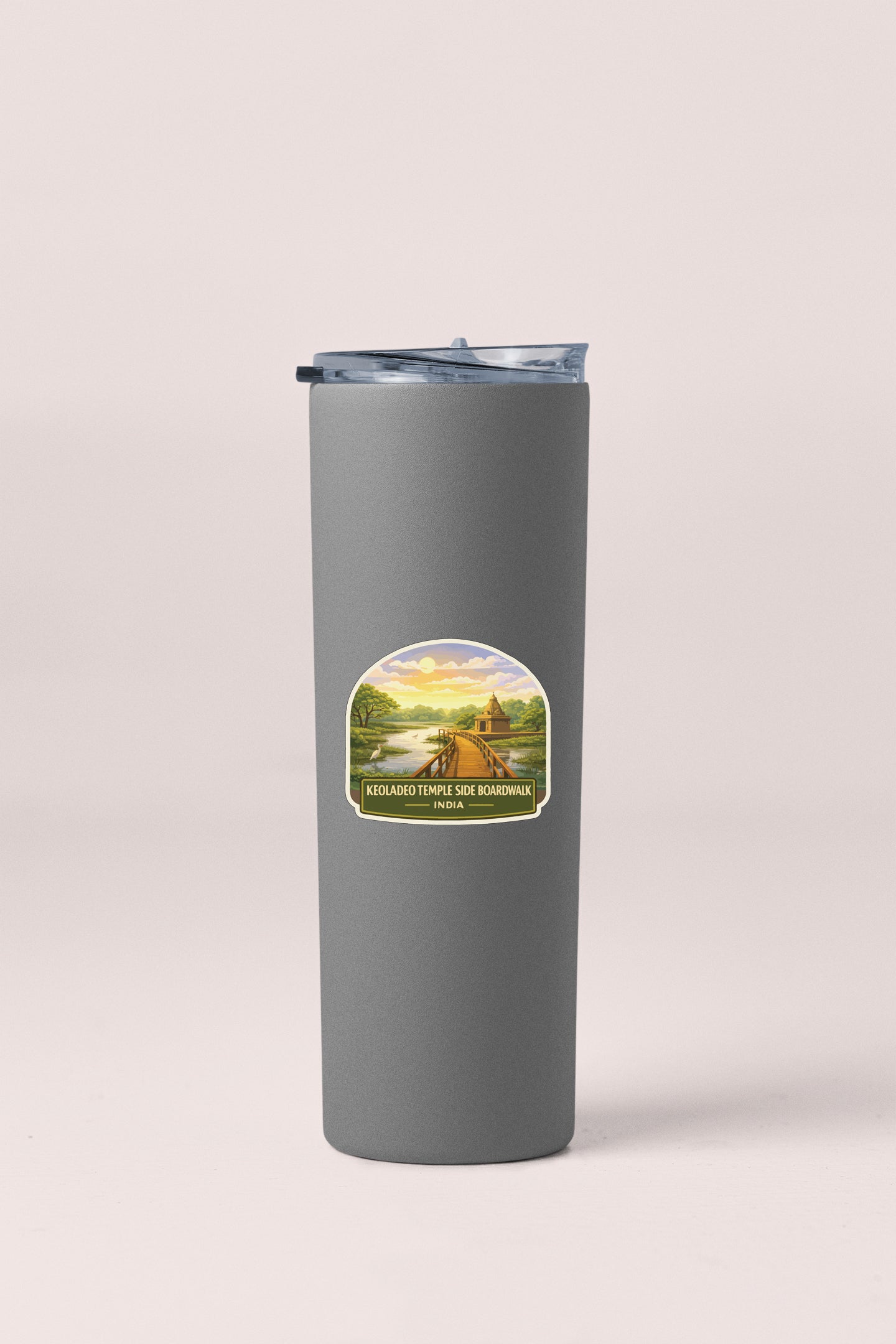 A gray insulated tumbler with a lid and a label featuring a scenic landscape.