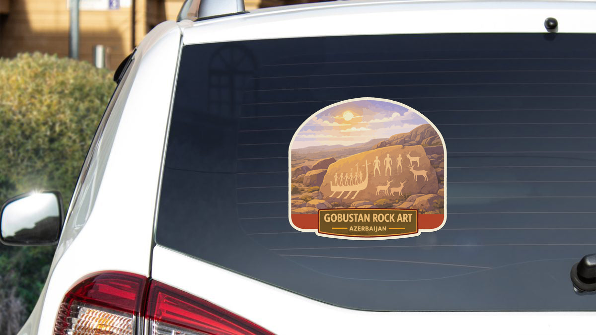 a sticker on the rear window of a white car, depicting a scenic landscape with a mountain range and a sunrise or sunset.