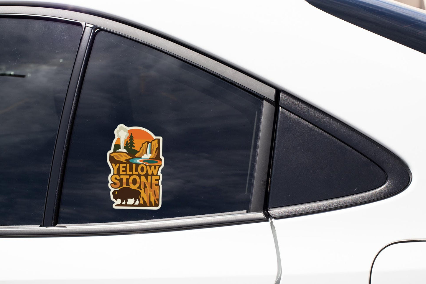 A car window with a sticker depicting a scenic landscape, including a mountain range and a waterfall.
