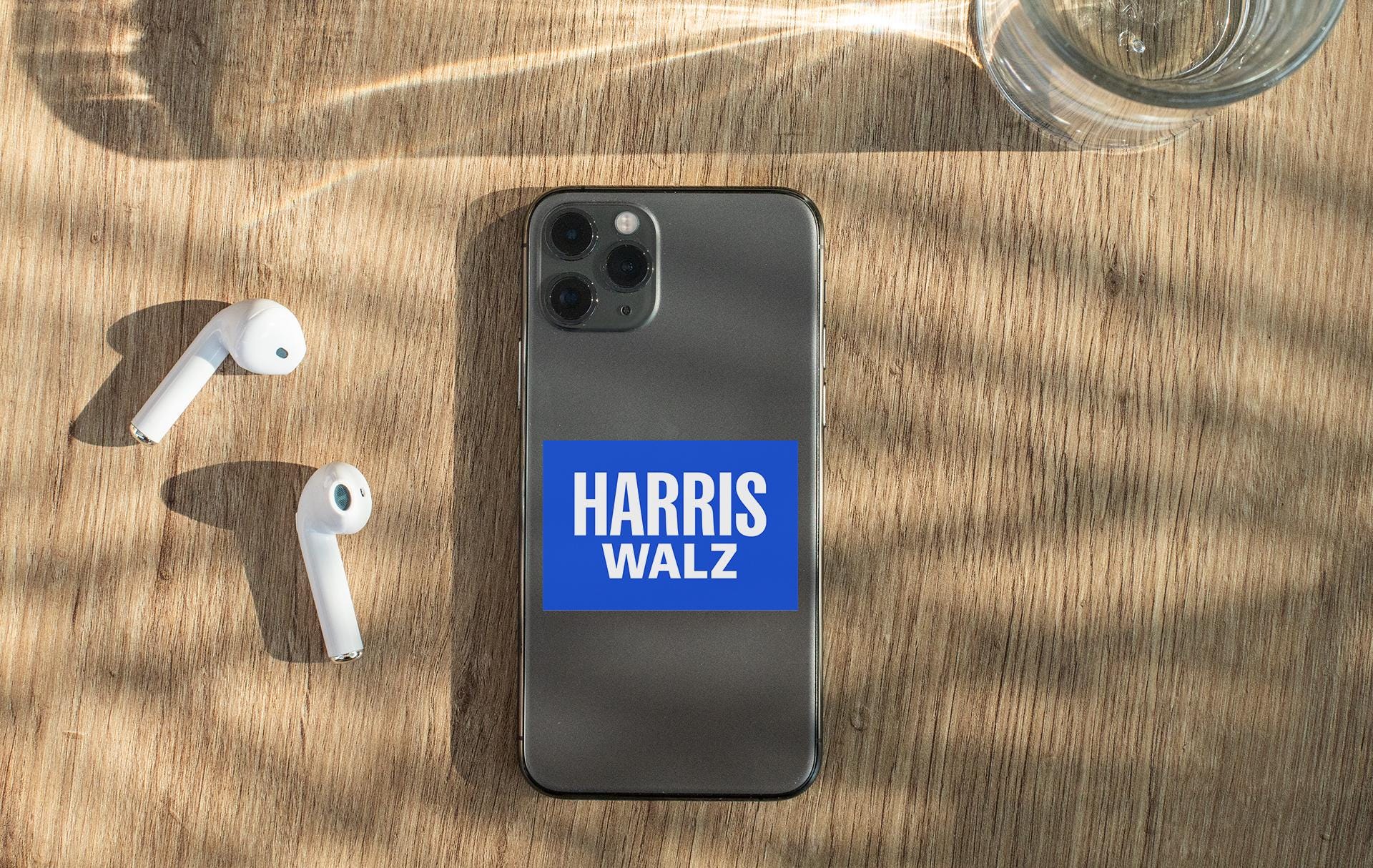a phone with a sticker on it next to ear buds