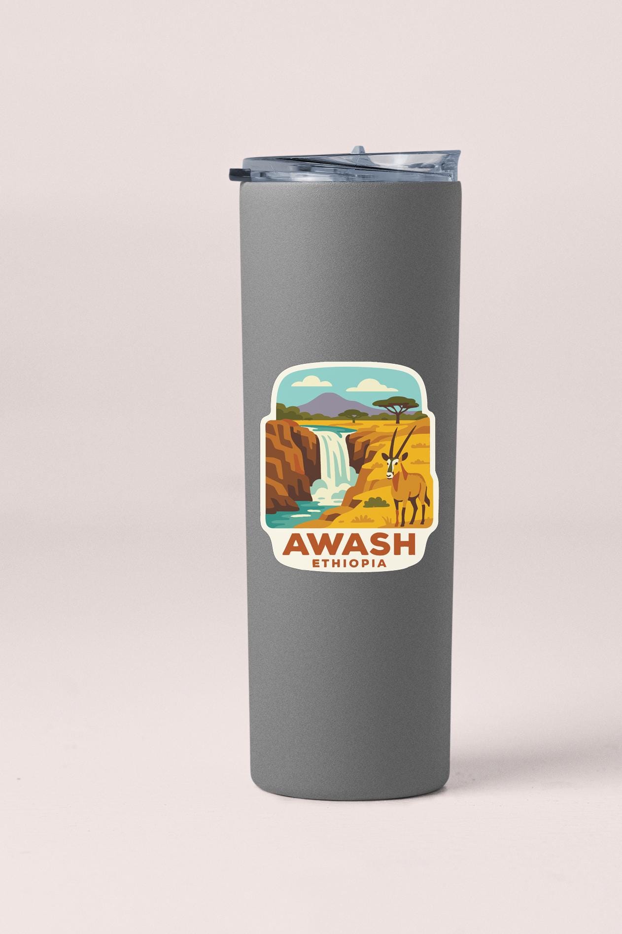 A gray tumbler with a sticker depicting a waterfall and a gazelle, along with the text "AWASH ETHiopia".