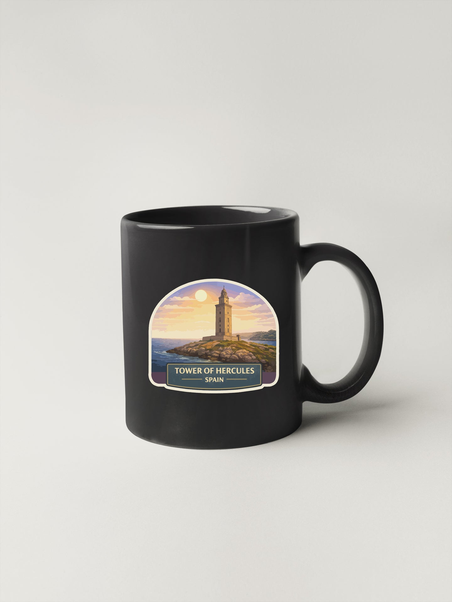 A black coffee mug with a graphic of the Tower of Hercules in Spain.
