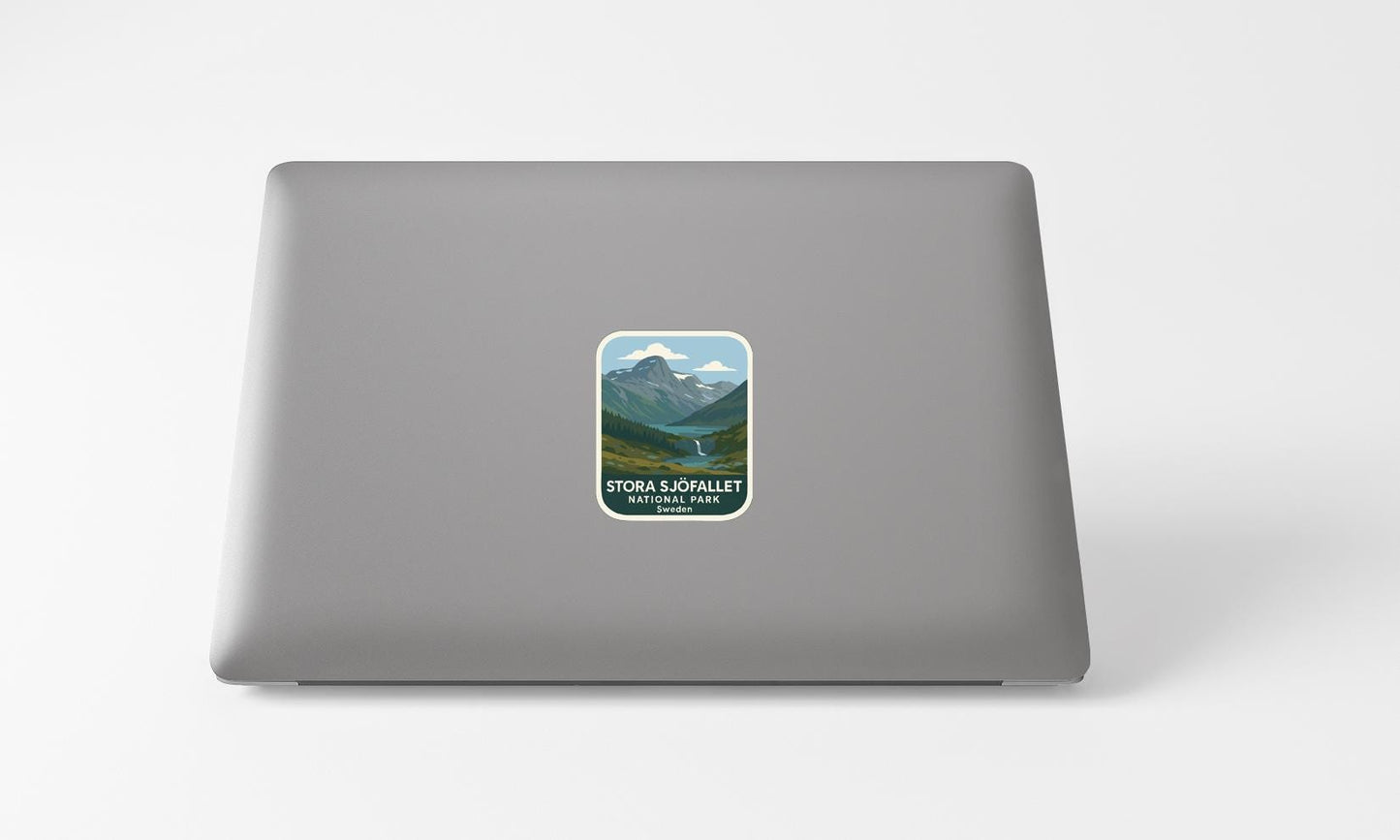 A sticker on the back of a laptop, depicting a scenic mountain landscape with a river and clouds.