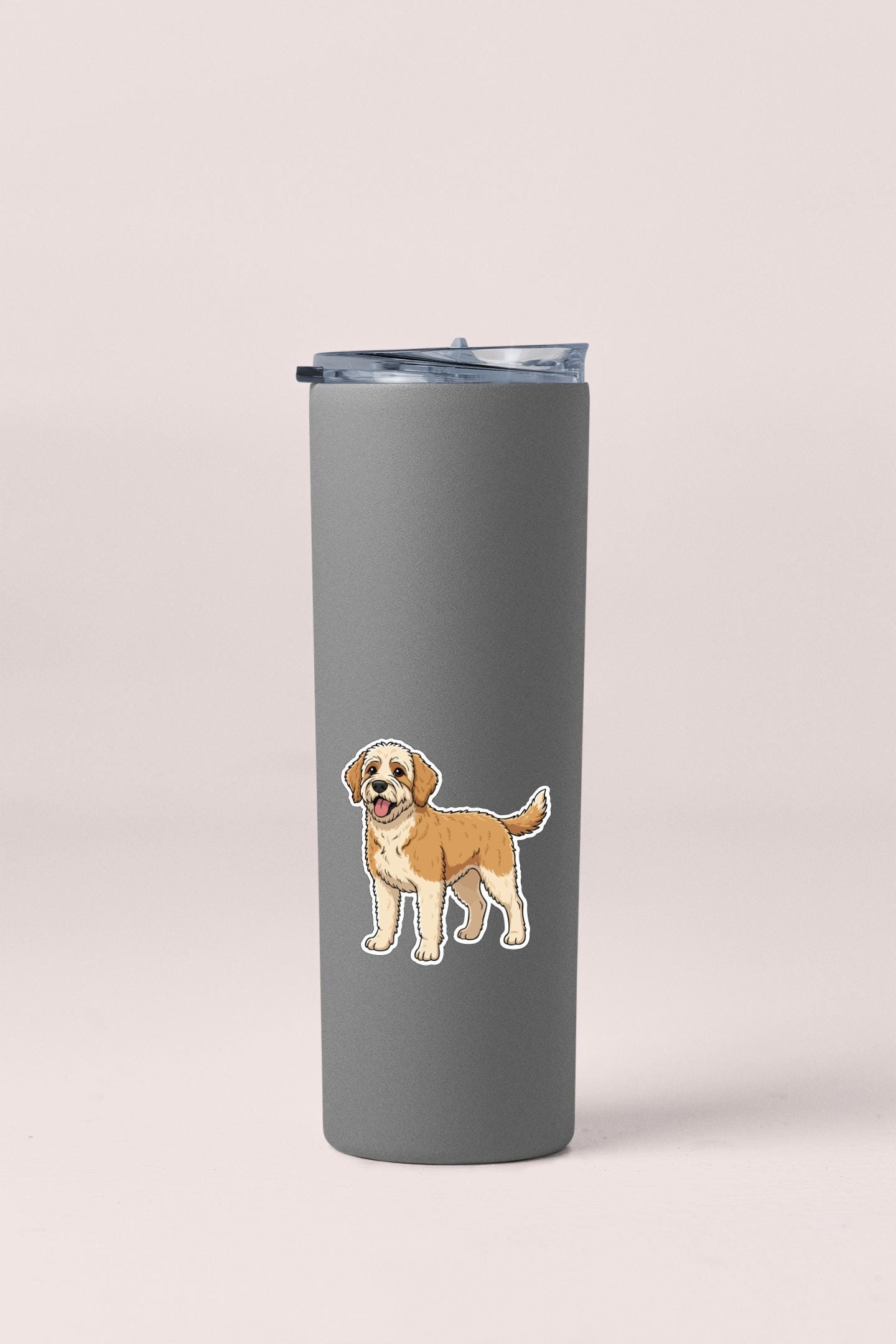 A gray insulated tumbler with a sticker of a cartoon dog on it.