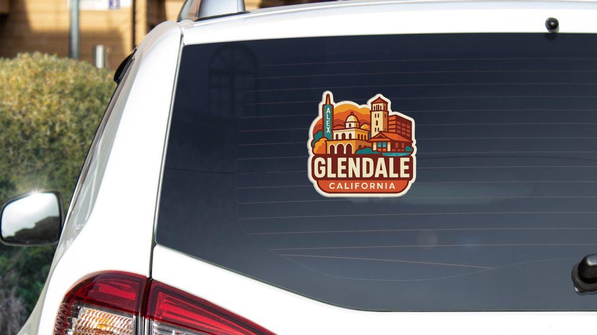 A sticker on the rear window of a white car that says "Glendale, CA".