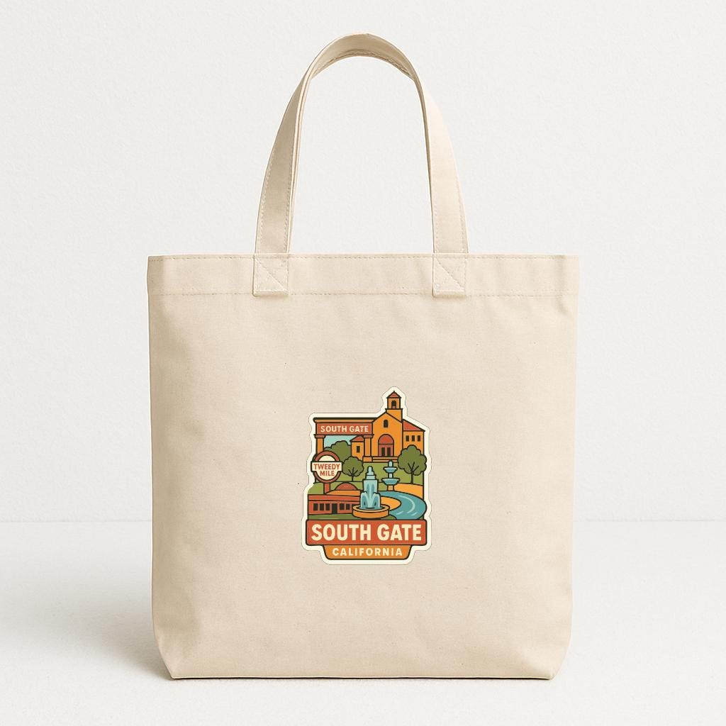 A beige tote bag with a printed design depicting a landmark, specifically South Gate, California.