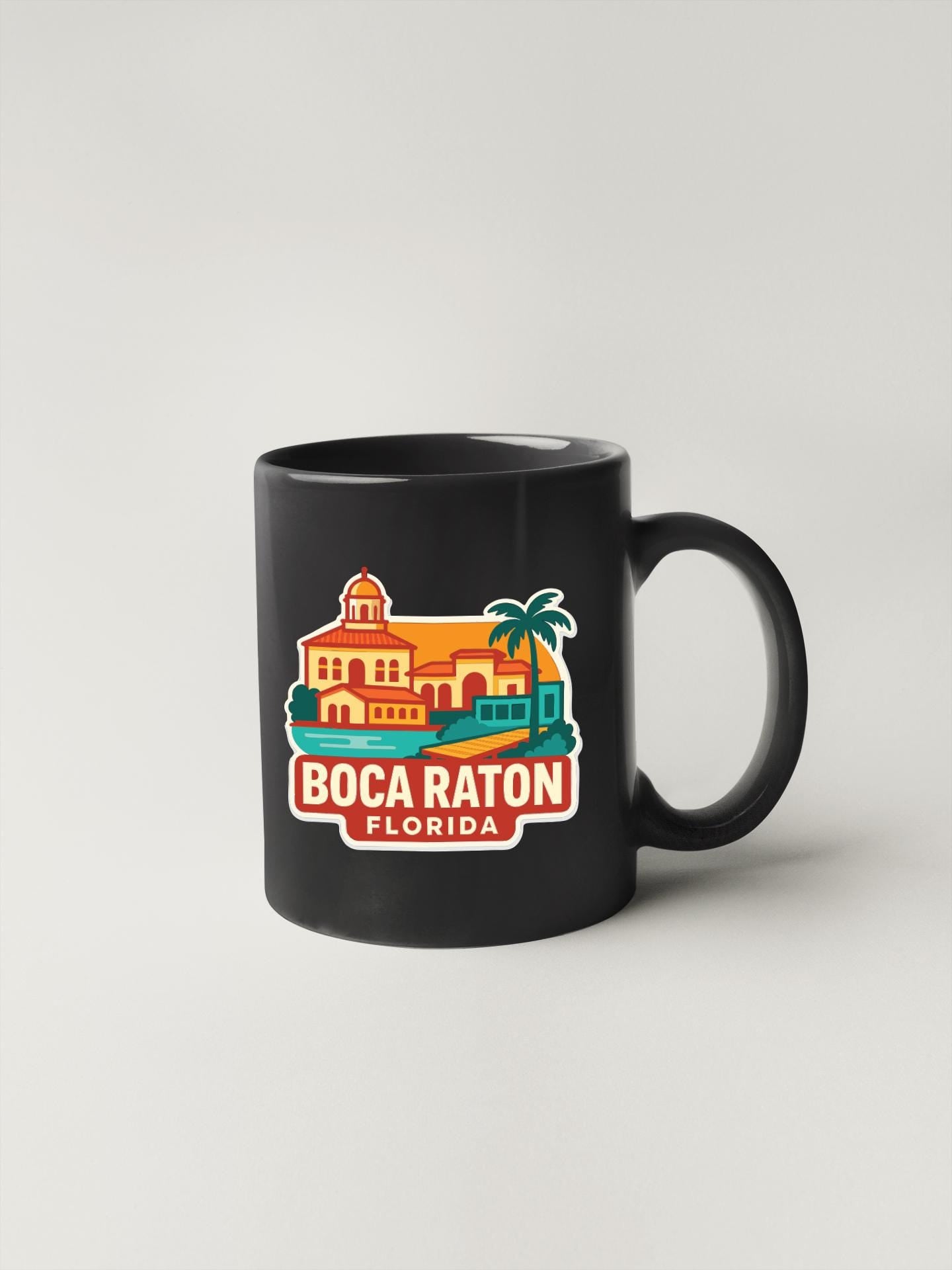 A black coffee mug with a colorful illustration of a building and palm trees, along with the text "Boca Raton, Florida".