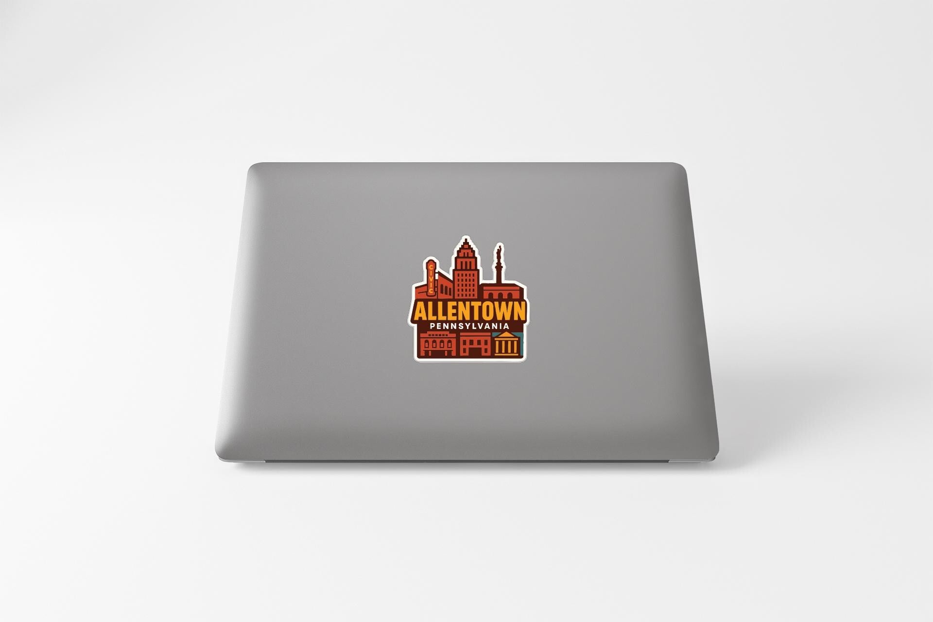 a sticker with a graphic of a city skyline on the back of a laptop.