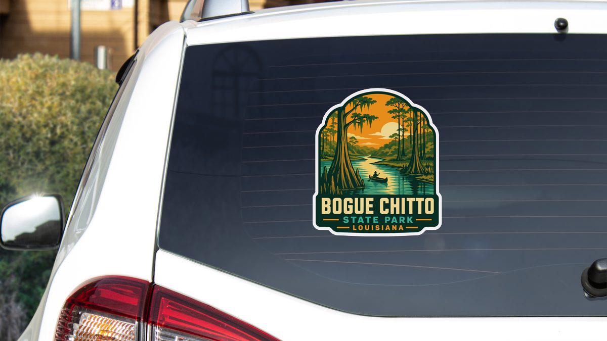 A sticker on the rear window of a white car, depicting a scenic landscape with a river and trees, along with the text "BOGUE CHITTO STATE PARK LOUISIANA".
