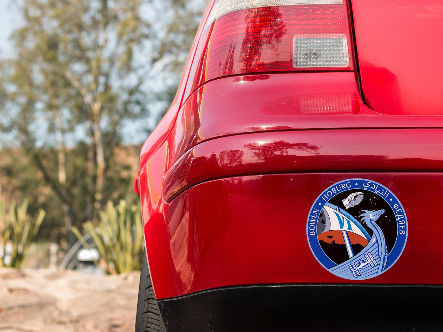 a close up of a red car with a sticker on it