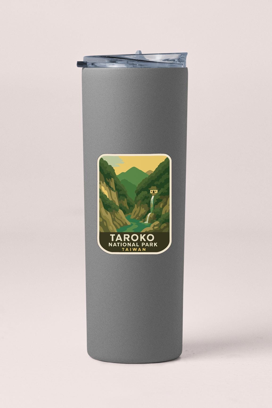 A gray insulated tumbler with a label that features an illustration of a waterfall and mountains, indicating that it is a product of Taroko National Park.