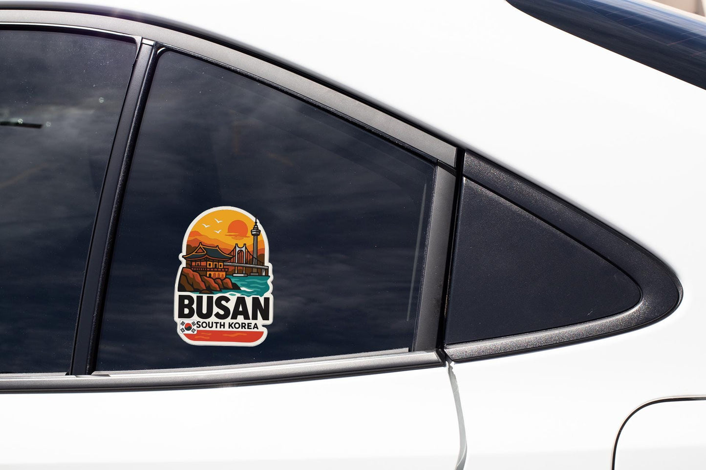 A sticker on the side of a car window, featuring a scenic image of Busan, South Korea.