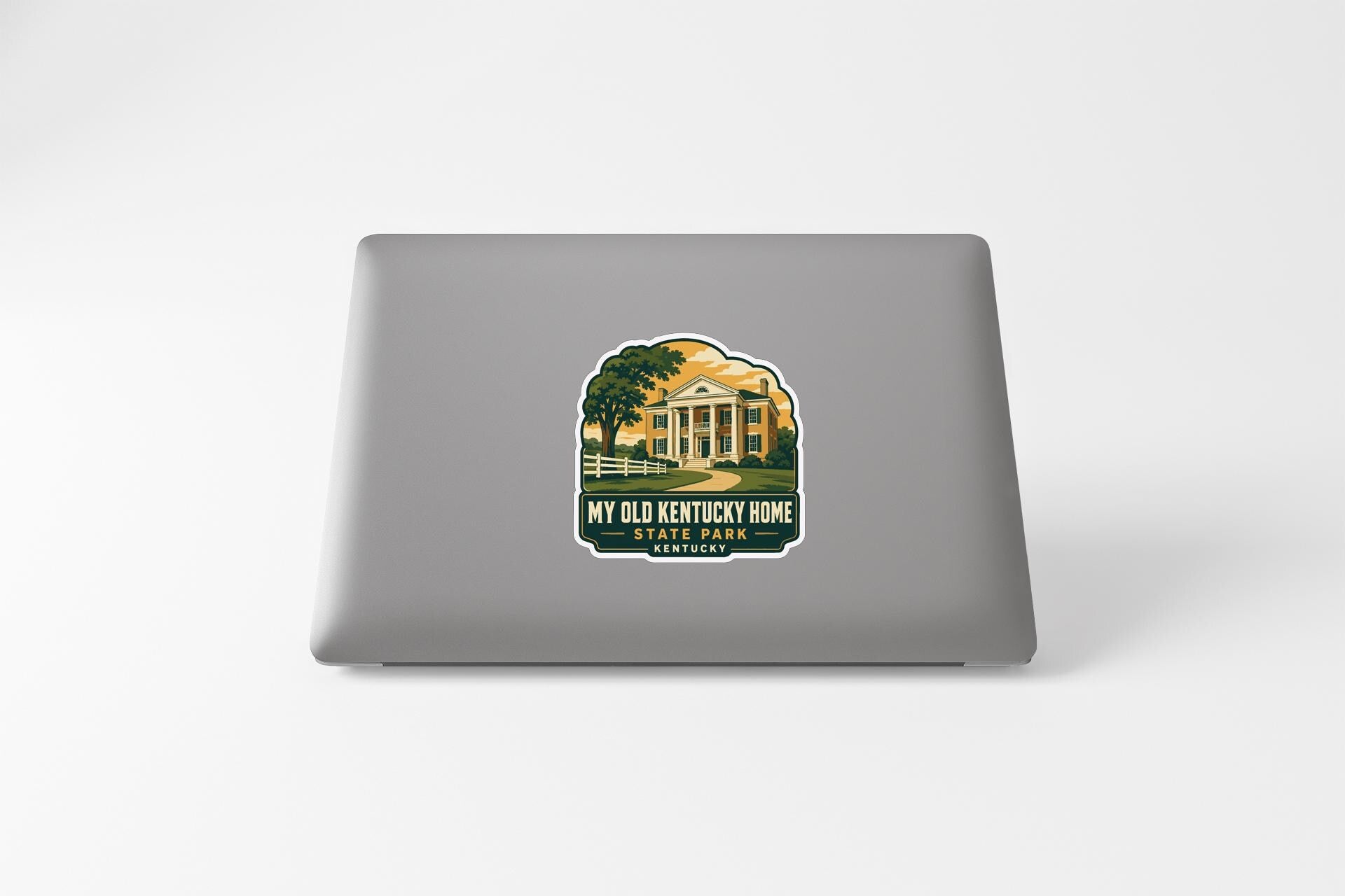 A sticker on the back of a laptop, depicting a house with a tree in the foreground.