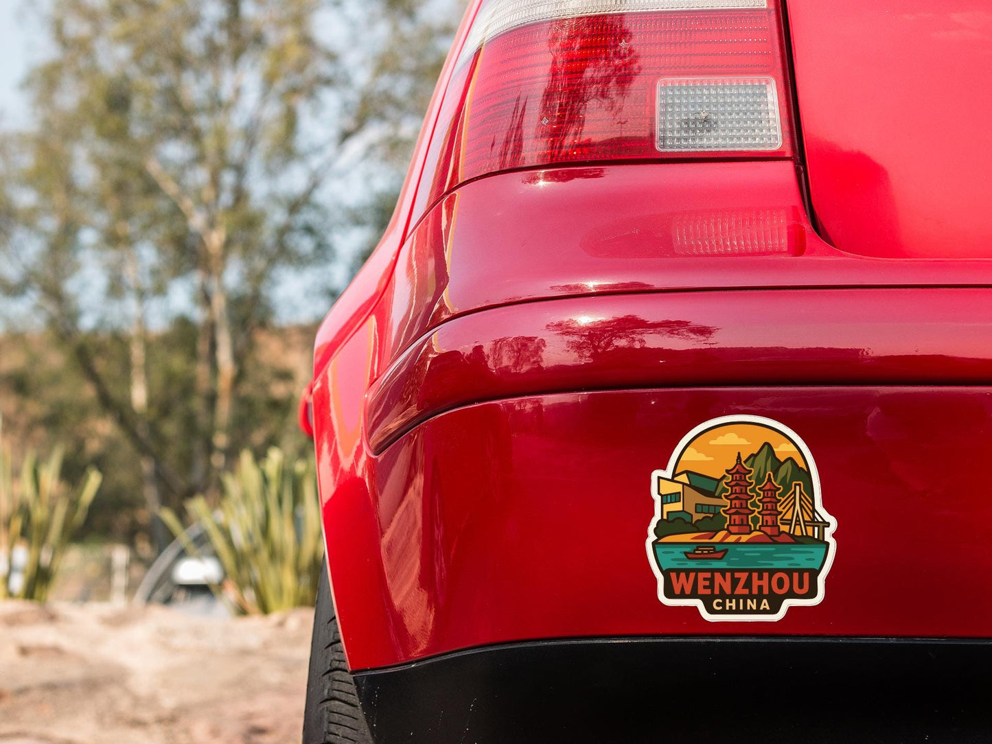 the rear end of a red car with a sticker on the trunk that says "Wenzhou China".