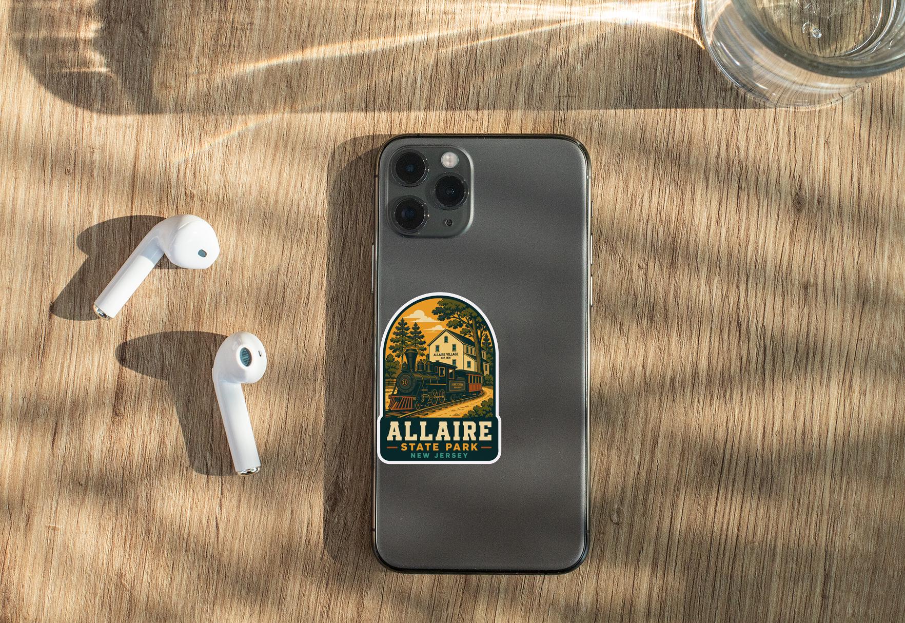 a smartphone with a sticker on it, placed on a wooden surface alongside a pair of white earbuds and a glass of water.
