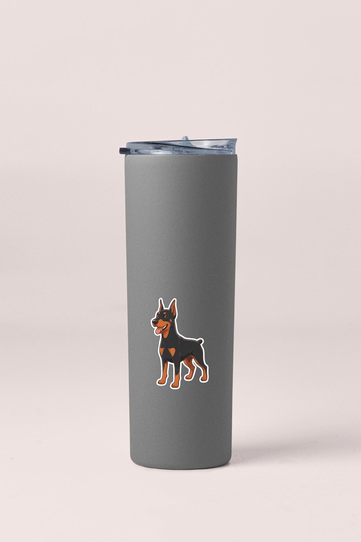 A gray insulated tumbler with a sticker of a dog on it.