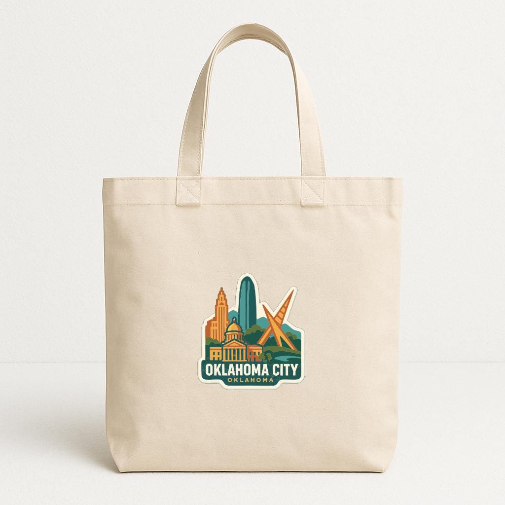 A beige tote bag with a printed design of the Oklahoma City skyline and the text "OKLAHOMA CITY" printed on it.